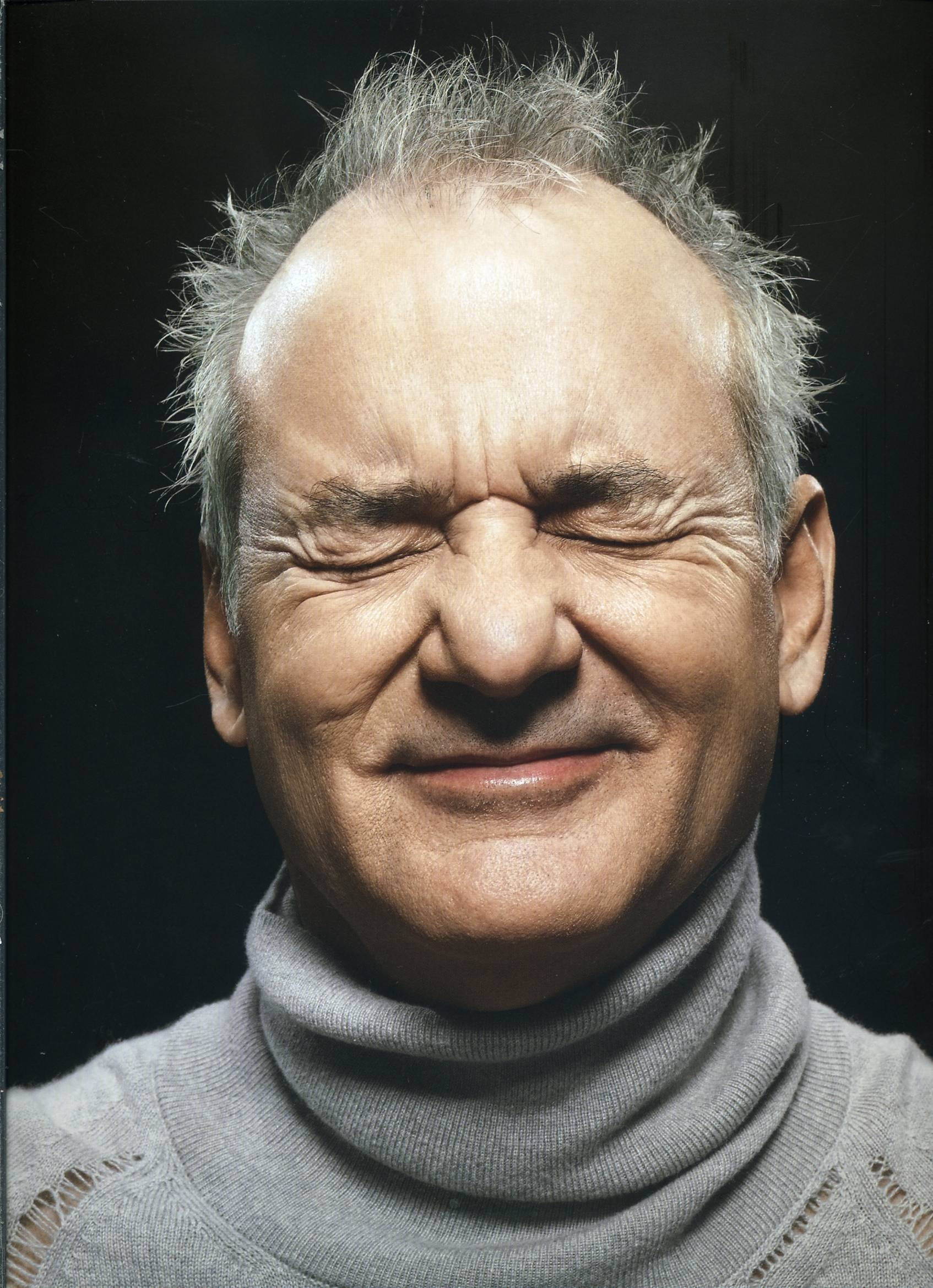 Celebrity 桌布 壁紙 — 一個頭髮花白的男士特寫肖像，在深色背景下，他閉著眼睛露出溫暖的笑容，表情充滿喜悅。