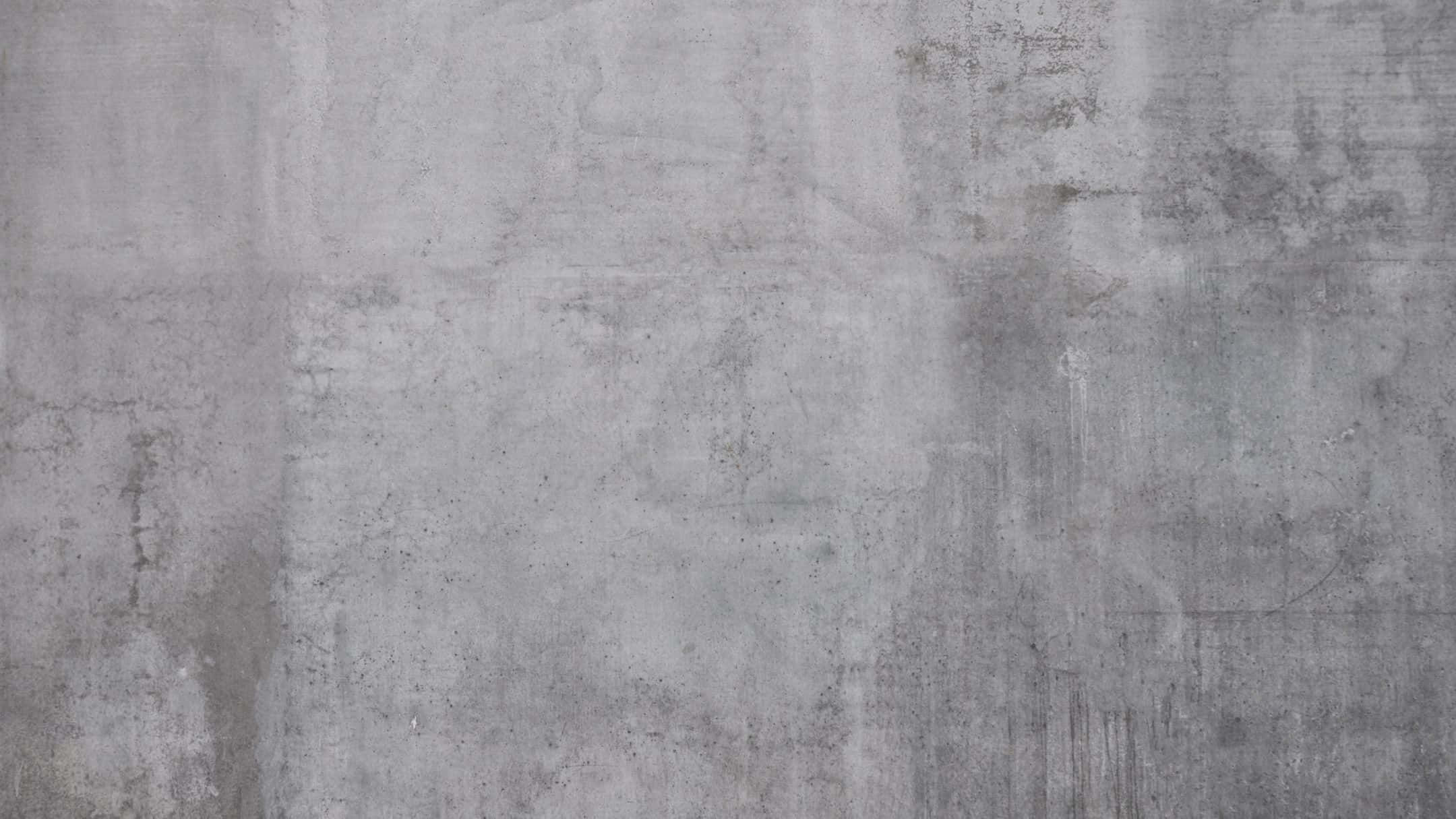 Wall Texture 桌布 壁紙 — 一個風化灰色混凝土牆的特寫，帶有可見紋理和細微污漬。