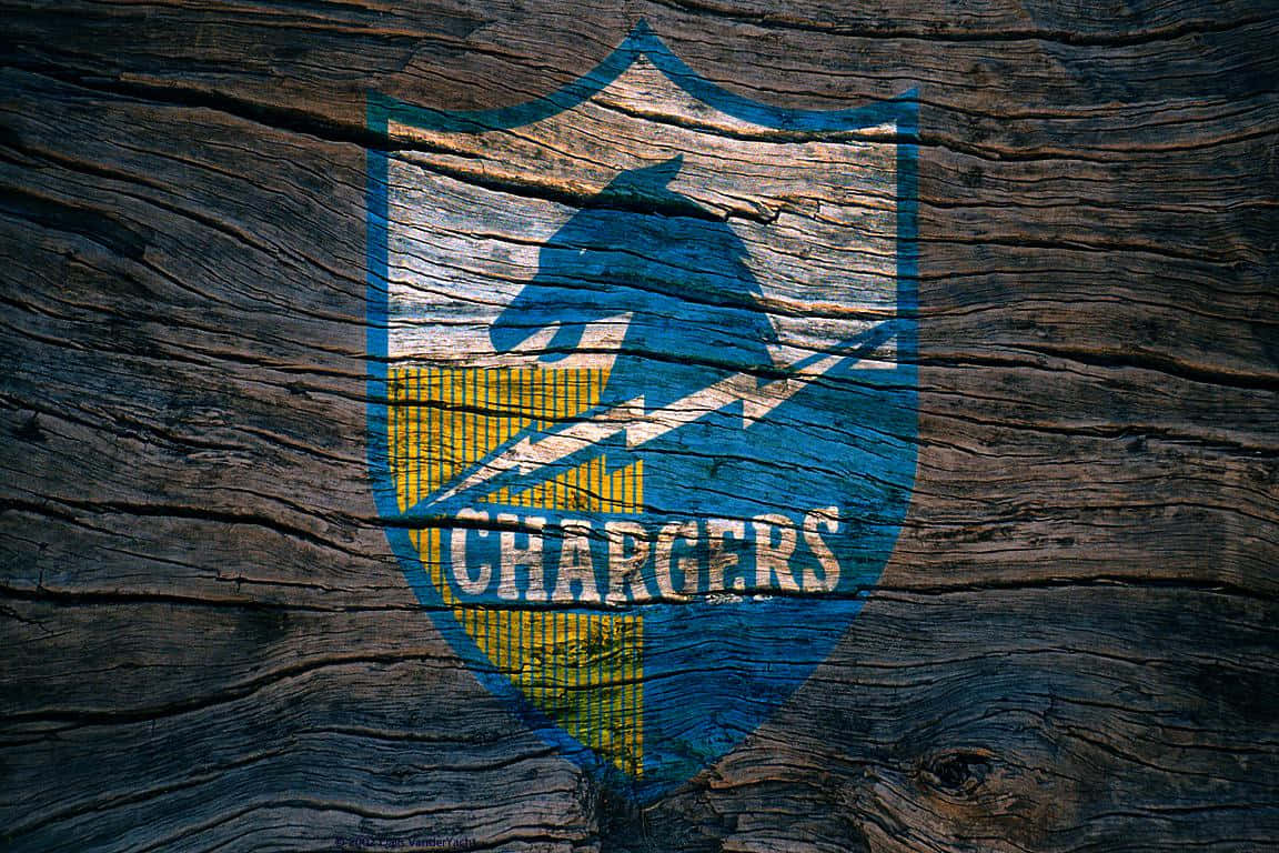 桌布 壁紙 — 一個風化的 Chargers 標誌，塗在粗糙的深色木頭上，帶有藍色、黃色和白色。