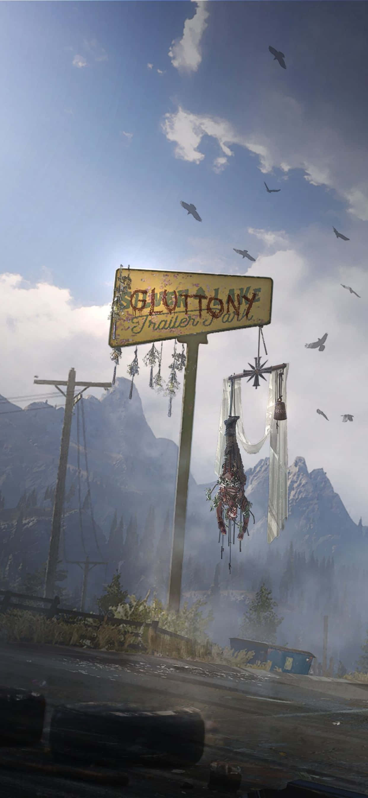 iPhone Xs Max Far Cry 5 桌布 壁紙 — 一個風化的「Glottony Trailer Park」標誌歪斜地掛在一條荒涼的道路上，背景有山脈和鳥兒飛過。