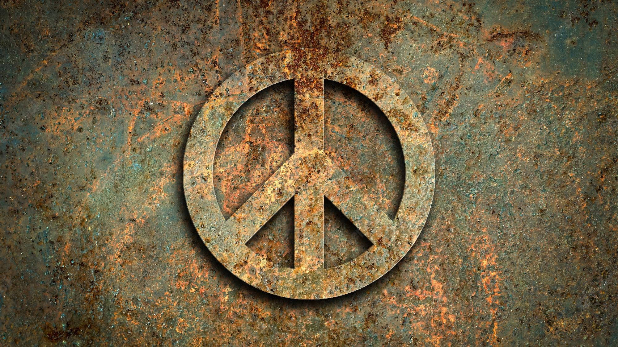 Peace Symbol 桌布 壁紙 — 一個風化的和平符號蝕刻在生鏽的金屬上，帶有紋理的橙色和藍綠色銅鏽。
