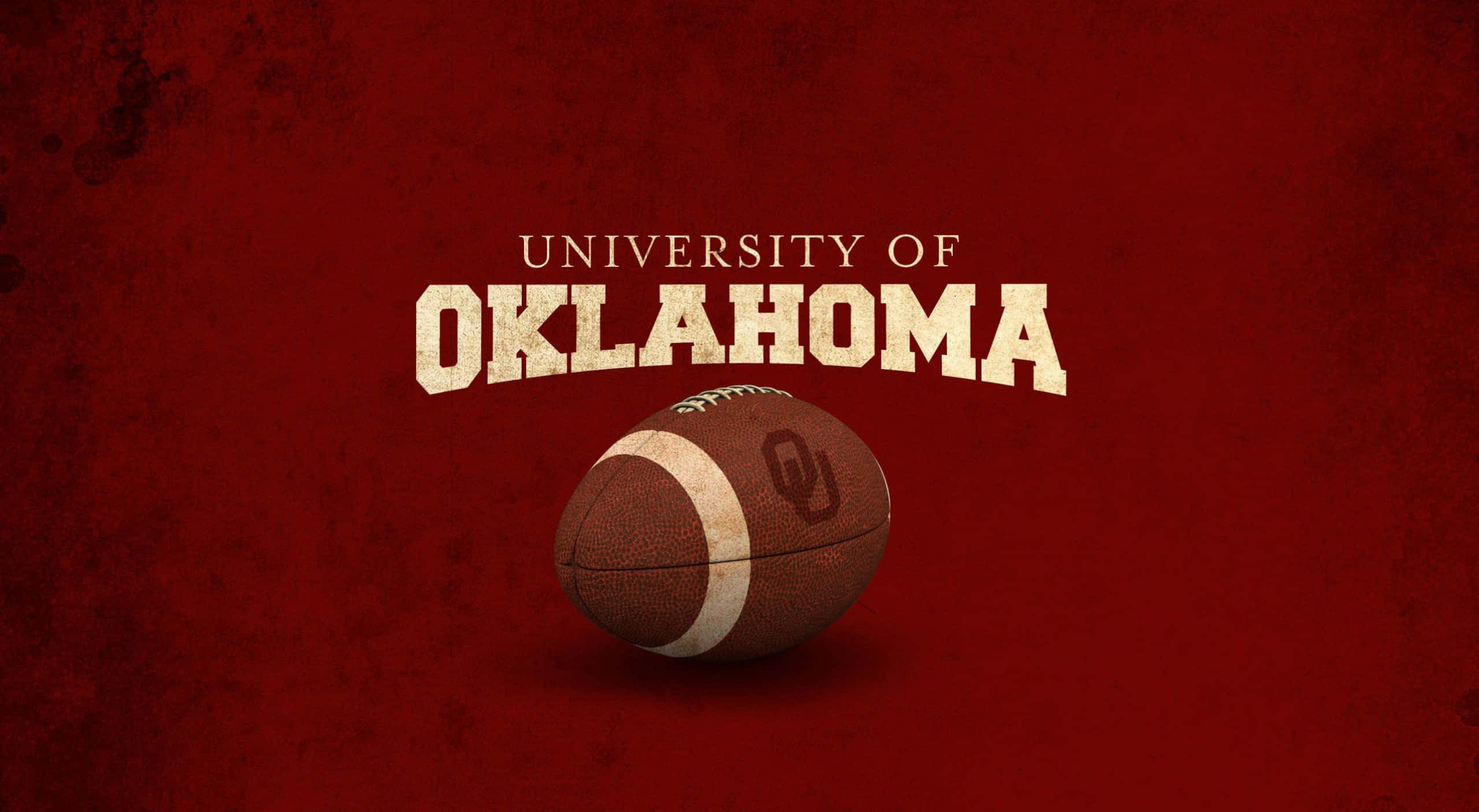 Oklahoma 桌布 壁紙 — 一個風化的奧克拉荷馬大學 Sooners 美式足球放在粗體球隊字樣下方，背景為有紋理的深紅色。