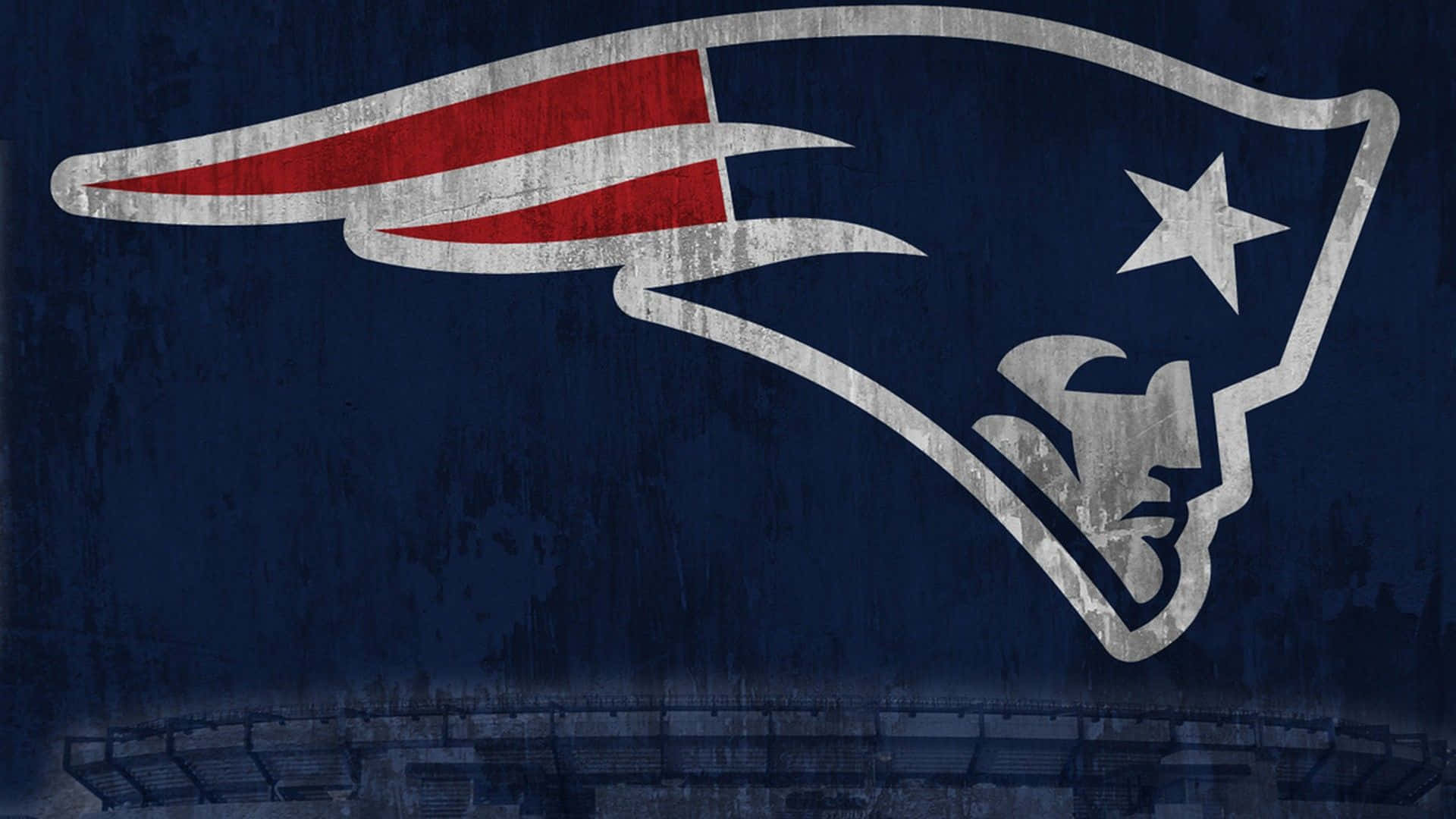 Patriots 桌布 壁紙 — 一個風化的新英格蘭愛國者隊標誌主導了深藍色體育場背景，下方可見看台。