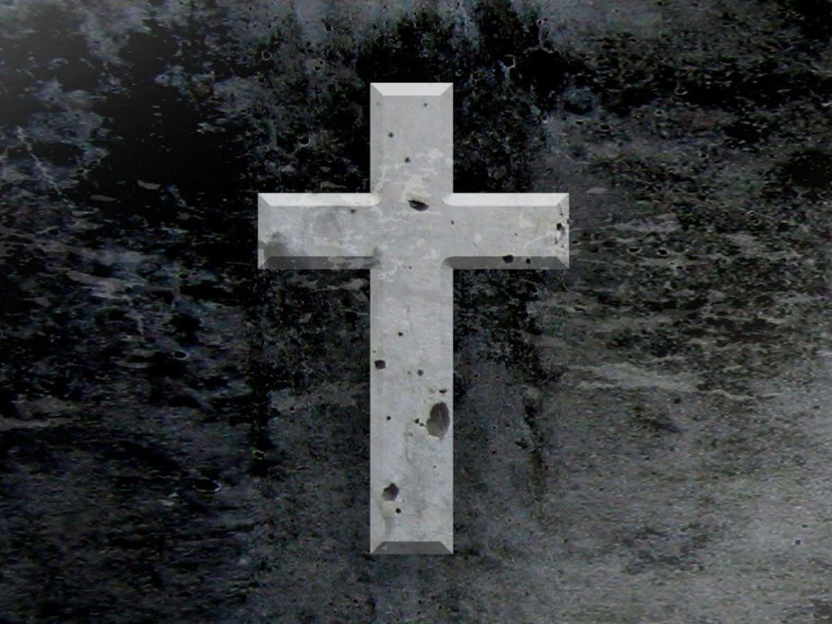 Cool Cross 桌布 壁紙 — 一個風化的混凝土十字架，在深色紋理石頭背景前莊嚴地矗立。
