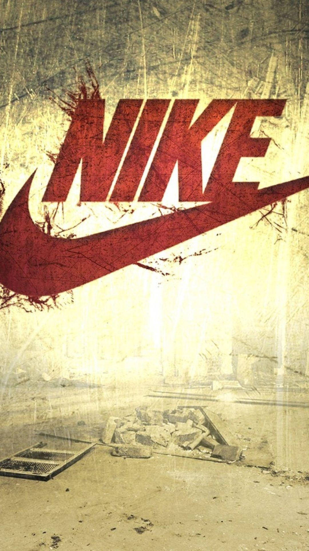 Nike iPhone 桌布 壁紙 — 一個風化的紅色Nike標誌主導著一個粗糙的城市衰敗場景，有破碎的混凝土和碎片。
