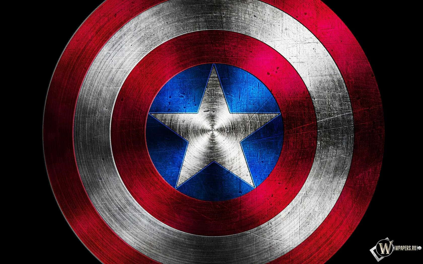 Captain America Logo 桌布 壁紙 — 一個風化的美國隊長盾牌，帶有紅、白、藍三色同心圓環，中央有一顆星，背景為黑色。