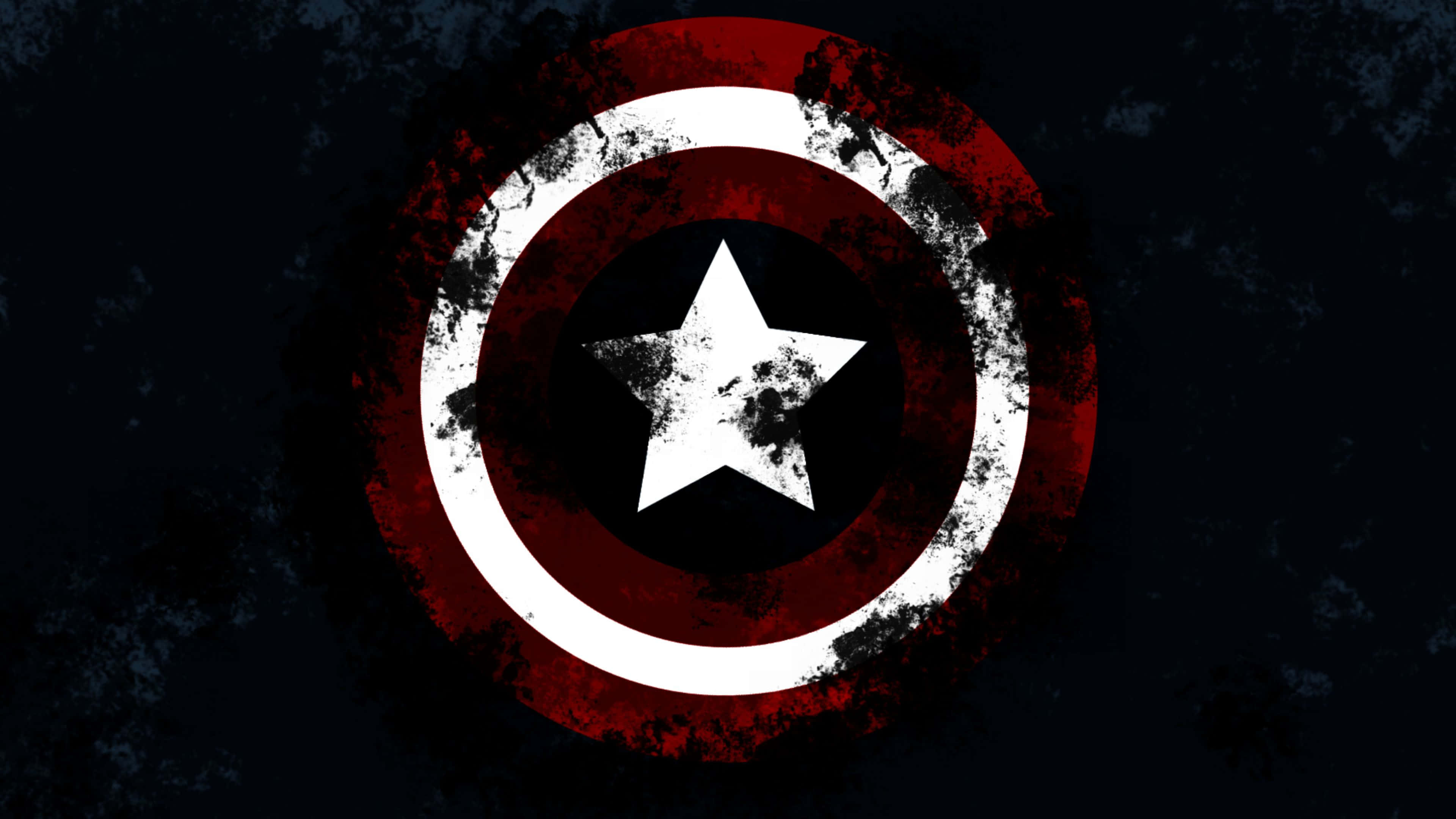 4K Captain America 桌布 壁紙 — 一個風化的美國隊長盾牌，有紅、白、藍色環和中間一顆星，背景是深色有紋理。