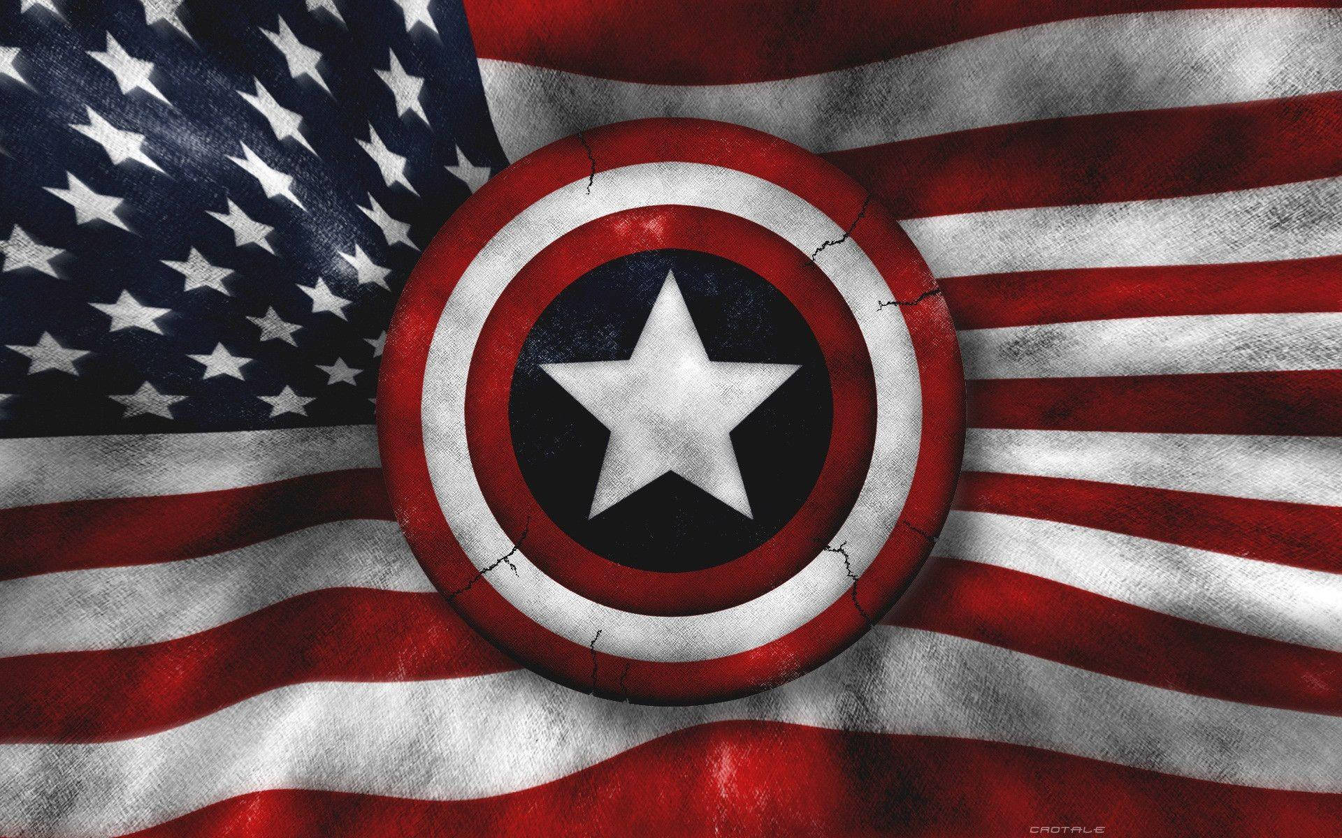 Military American Flag 桌布 壁紙 — 一個風化的美國隊長盾牌，置中在有紋理的美國國旗上，可見裂紋和布料摺痕。