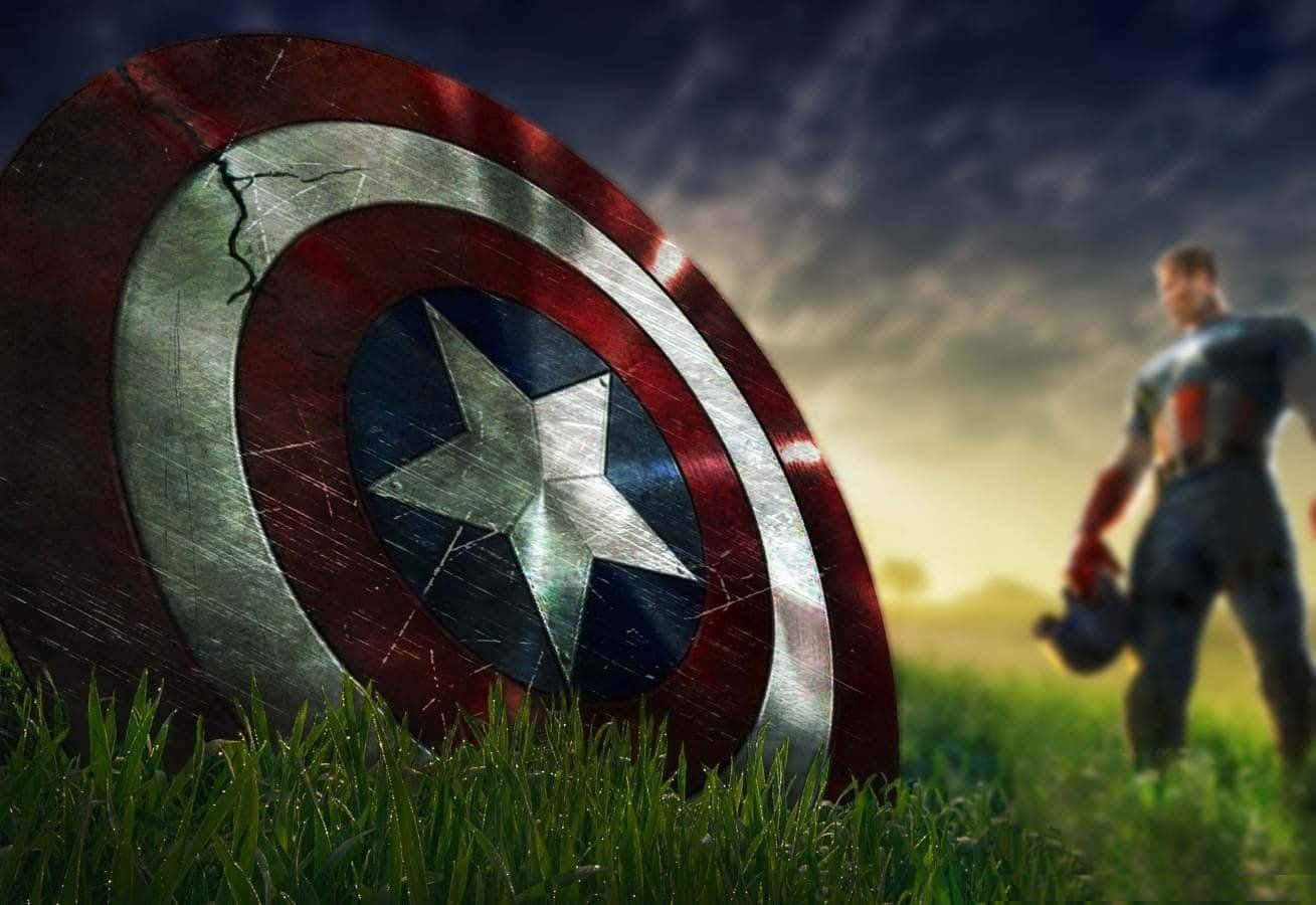 Best Marvel 桌布 壁紙 — 一個風化的美國隊長盾牌放在充滿活力的綠色草地上，英雄在遠處的戲劇性暮色天空下模糊地站著。