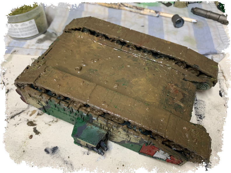 軍隊 桌布 壁紙 — 一個風化的軍用坦克模型放在濺滿油漆的工作檯上，周圍是模型工具和油漆。