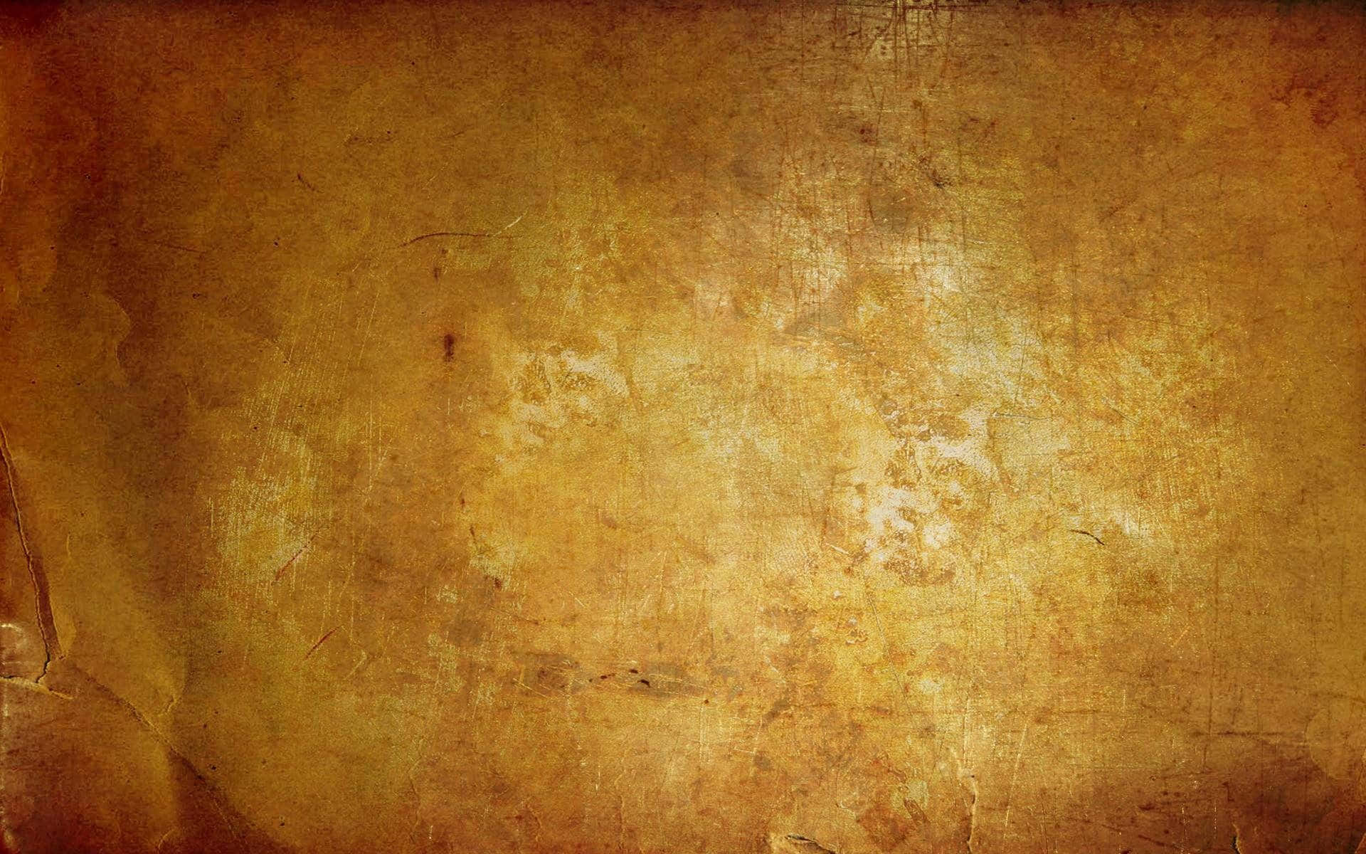 Grunge Texture 桌布 壁紙 — 一個風化的金棕色紋理表面，帶有刮痕和皺褶，類似於舊羊皮紙或復古壁紙。