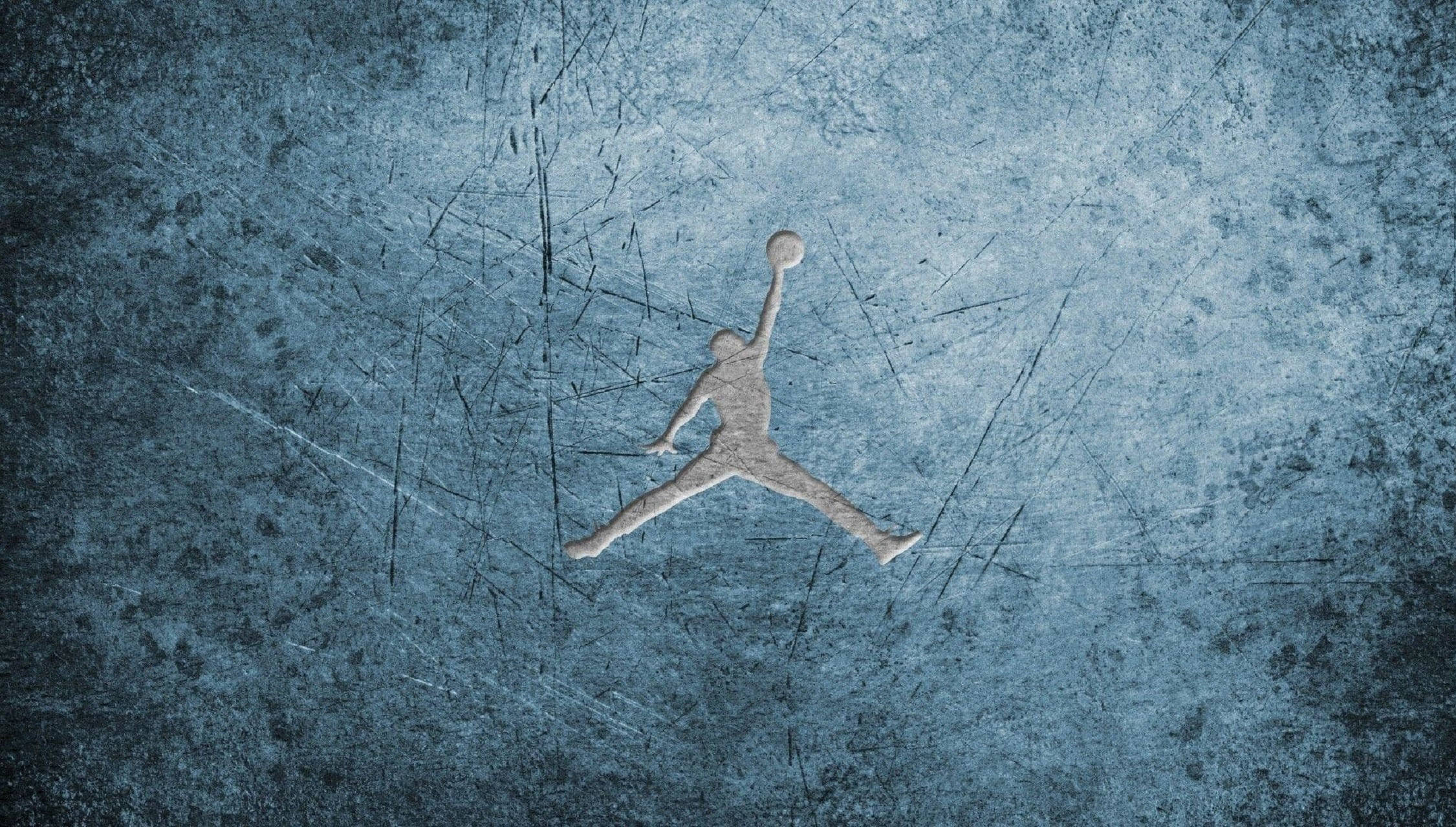 Air Jordan 桌布 壁紙 — 一個風化的銀色籃球運動員剪影，在空中持球，背景是刮花的藍色紋理背景。