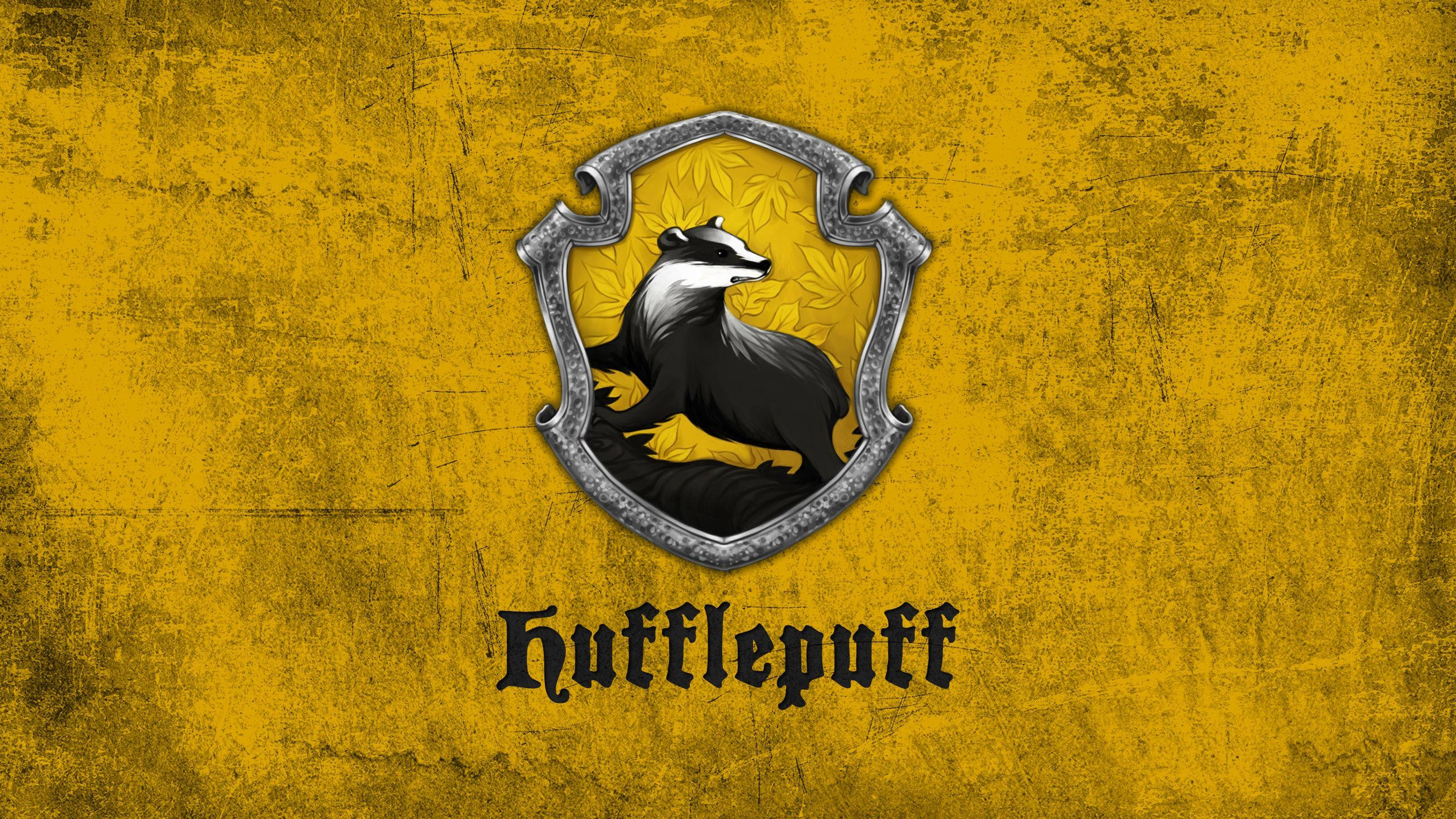 Hufflepuff 桌布 壁紙 — 一個風化的黃色背景上有一個銀色盾牌，上面有一隻黑白相間的獾，下方有Hufflepuff字樣。