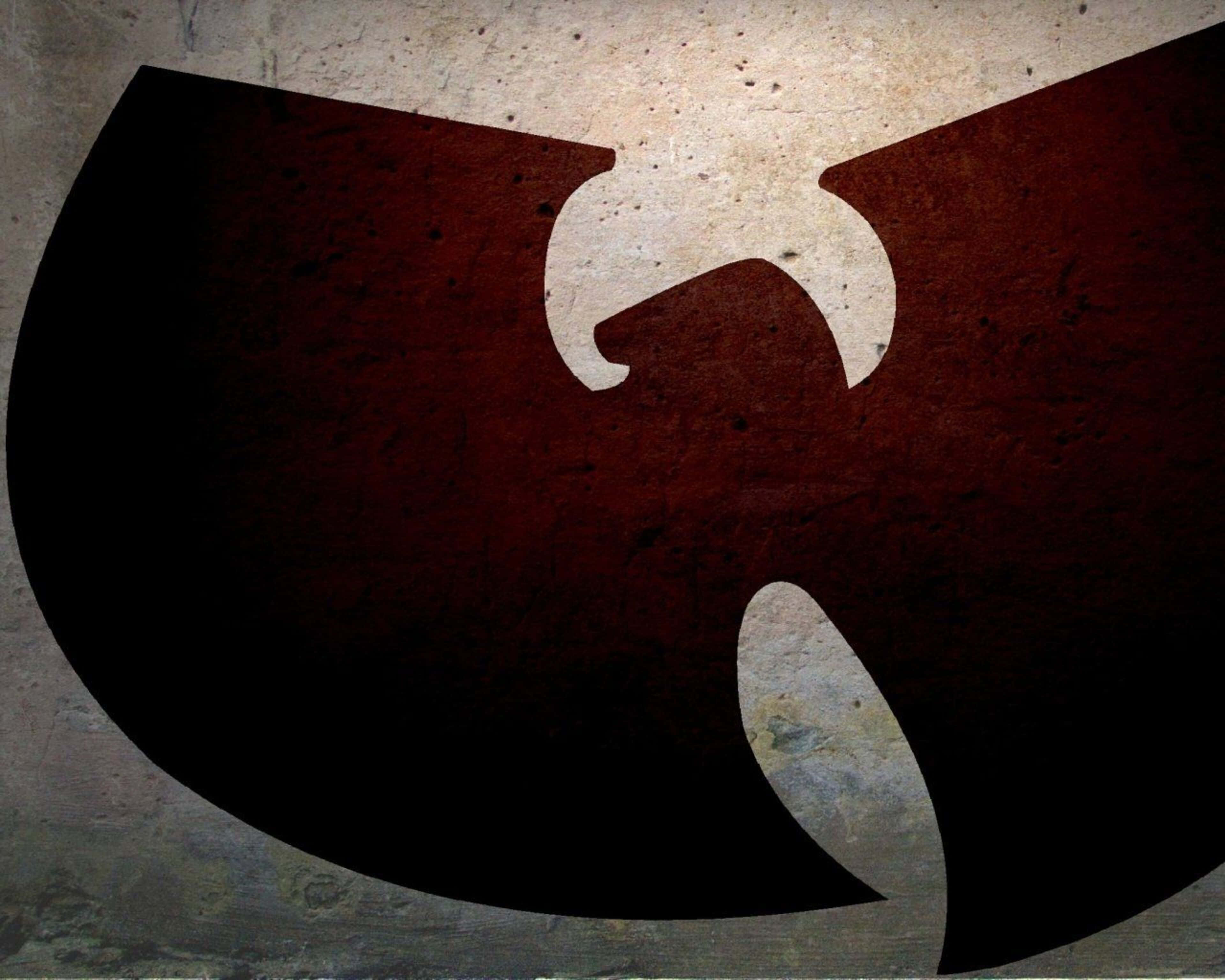 hiphop 桌布 壁紙 — 一個風格化的Wu-Tang Clan標誌，以醒目的黑色和紅色呈現在風化且帶有粗糙紋理的混凝土牆上。