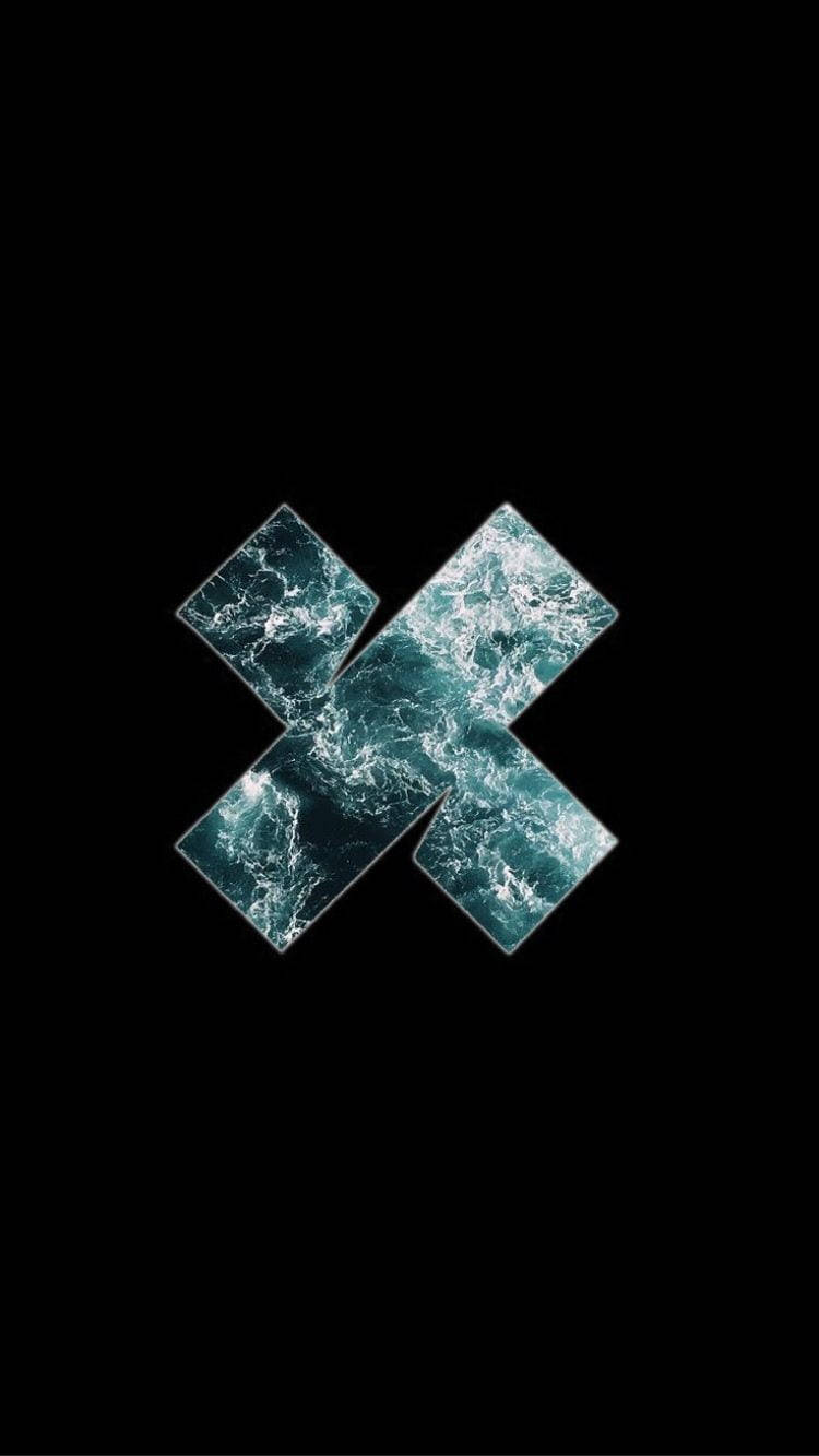 X 桌布 壁紙 — 一個風格化的X形狀，由四個鑽石瓷磚組成，帶有旋轉的青綠色海浪，背景為純黑色。
