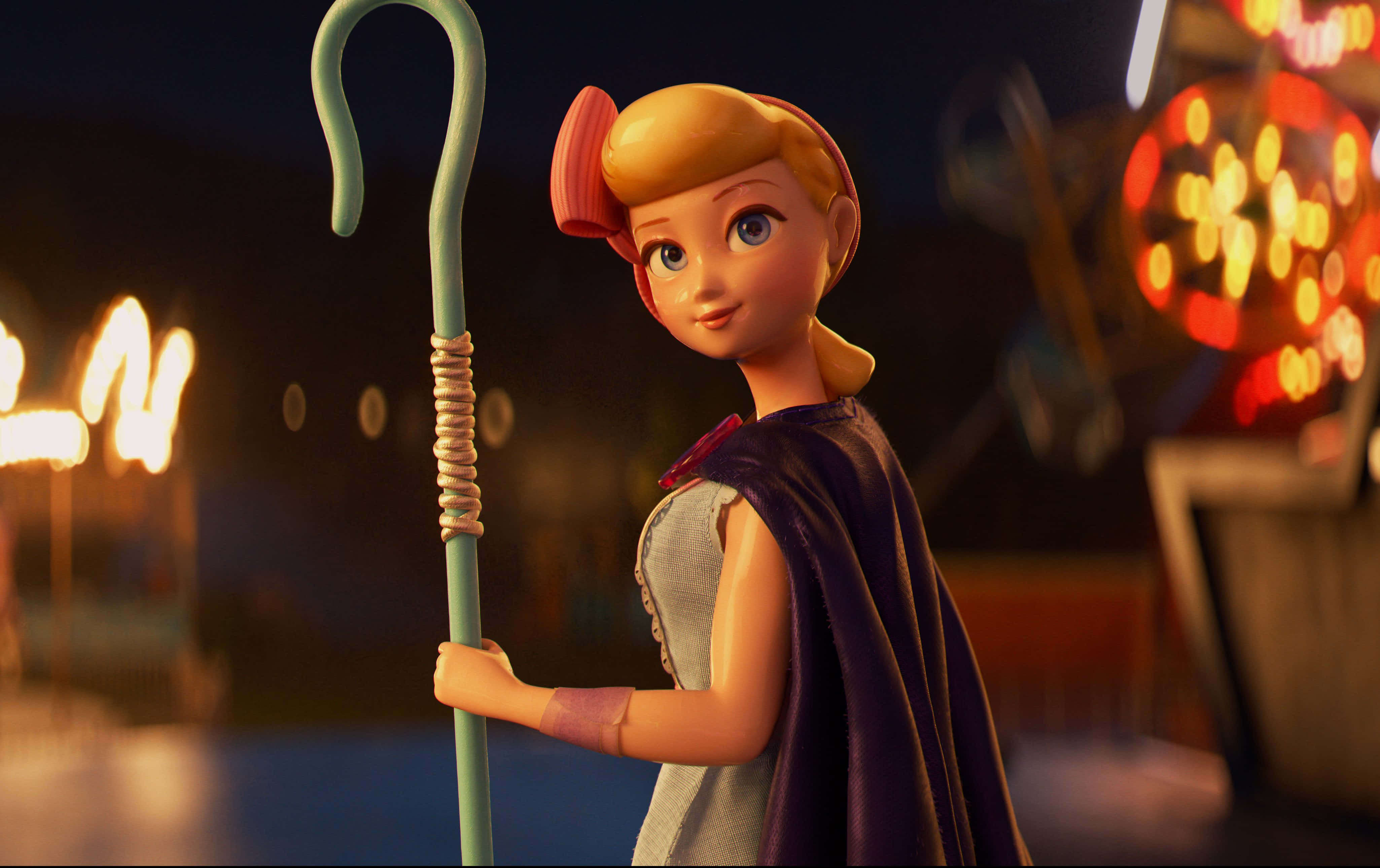 Toy Story 4 桌布 壁紙 — 一個風格化的動畫女孩，金髮，披著紫色斗篷，在夜晚模糊的嘉年華背景下拿著綠色的牧羊杖。