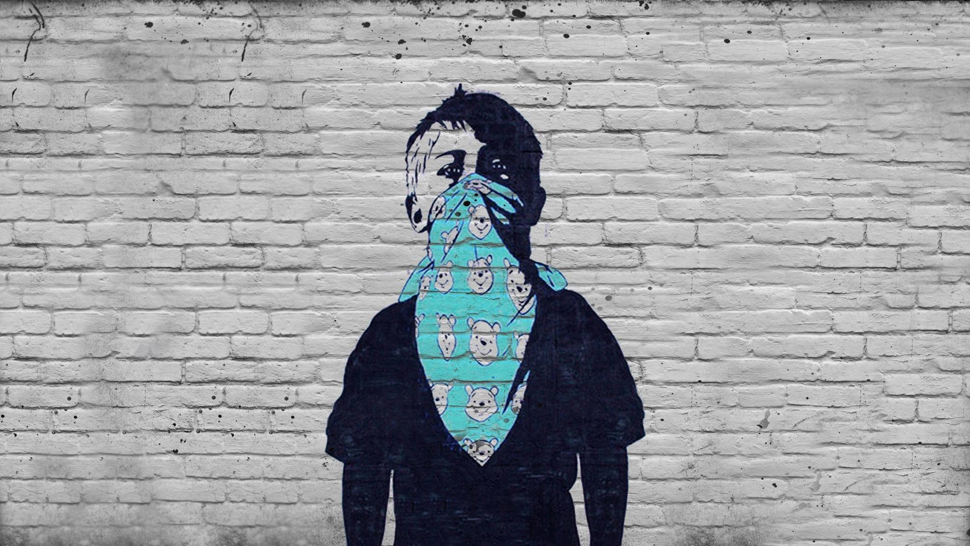 Banksy 桌布 壁紙 — 一個風格化的塗鴉人物，戴著藍色頭巾，上面有卡通熊圖案，站在風化的白色磚牆前。