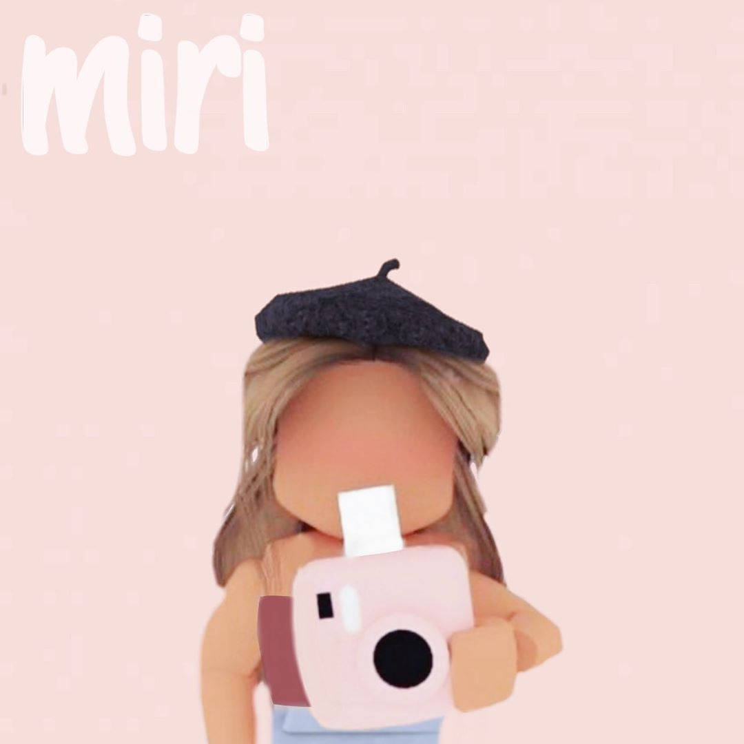 美學 Roblox 女孩 桌布 壁紙 — 一個風格化的數位頭像，金髮，戴黑色貝雷帽，在柔和的粉紅色背景前拿著一台粉紅色拍立得相機。