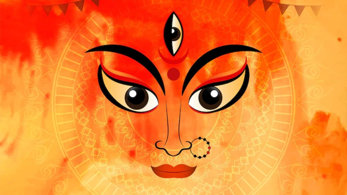 Mata Rani 桌布 壁紙 — 一個風格化的神聖面孔，帶有第三隻眼和華麗圖案，散發出火熱的橙色和金色色調。