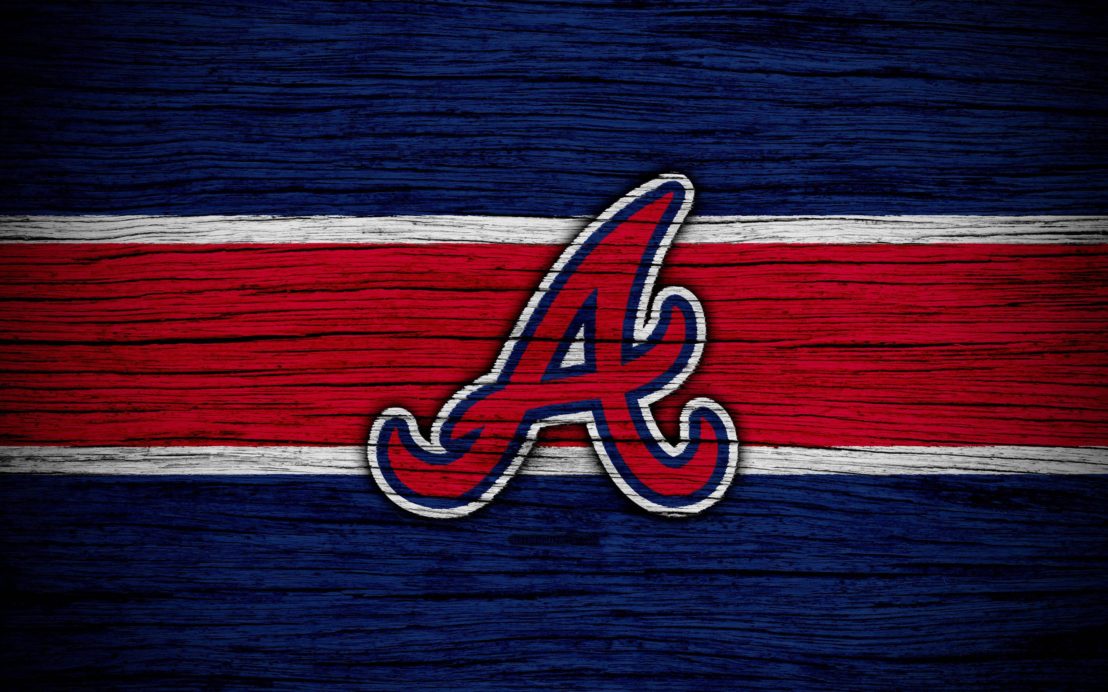 Braves 桌布 壁紙 — 一個風格化的紅、白、藍 'A' 標誌放置在帶有水平條紋的風化木質表面上。
