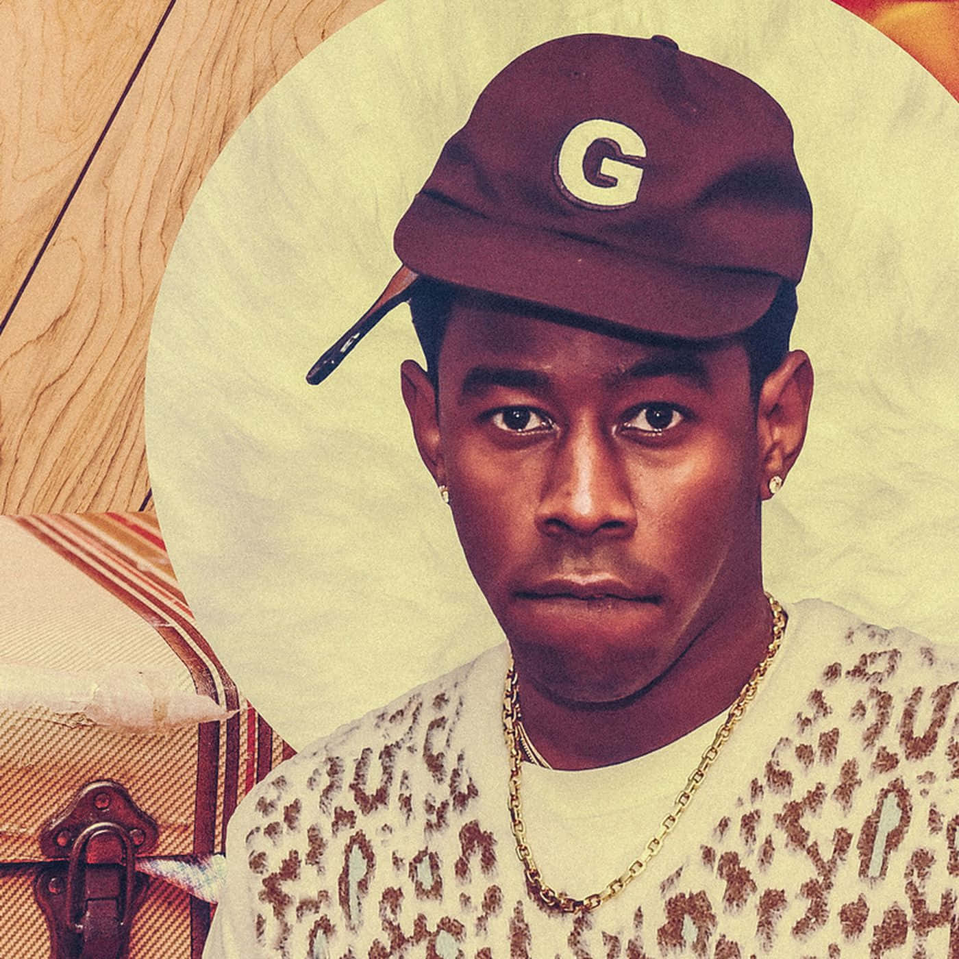 Rappers 桌布 壁紙 — 一個風格化的肖像，一個戴著帶有G標誌的栗色帽子和豹紋毛衣的男人，背景是帶有木紋質感的圓形奶油色背景。