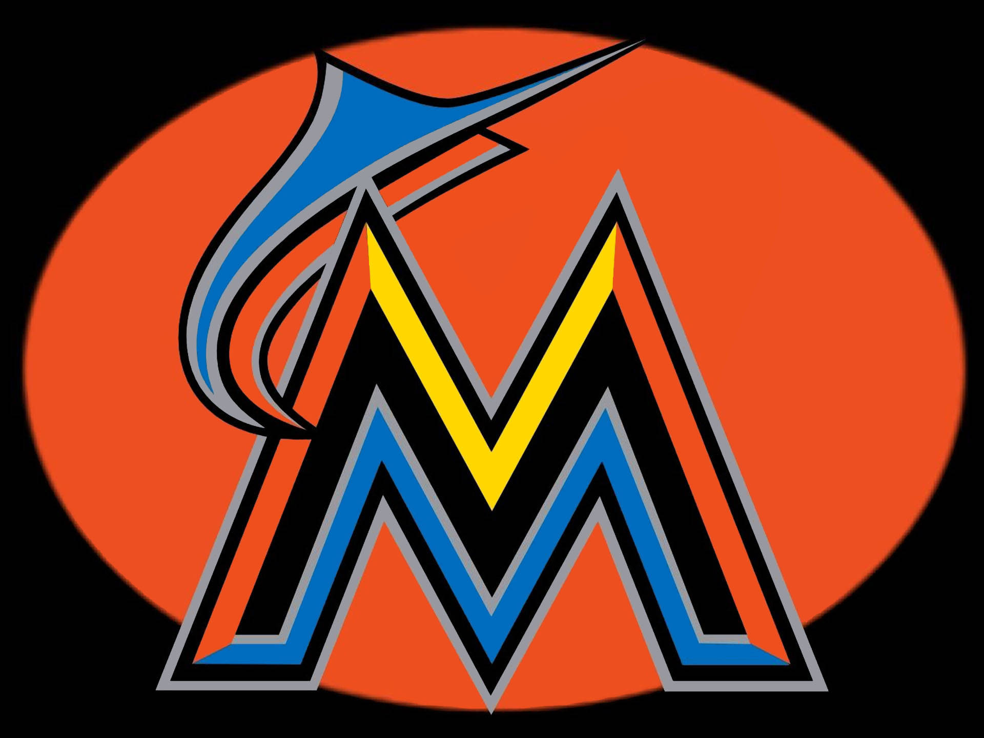 Marlins 桌布 壁紙 — 一個風格化的藍黃色「M」標誌，有一條馬林魚躍過它，置於黑色背景上的橙色橢圓形內。