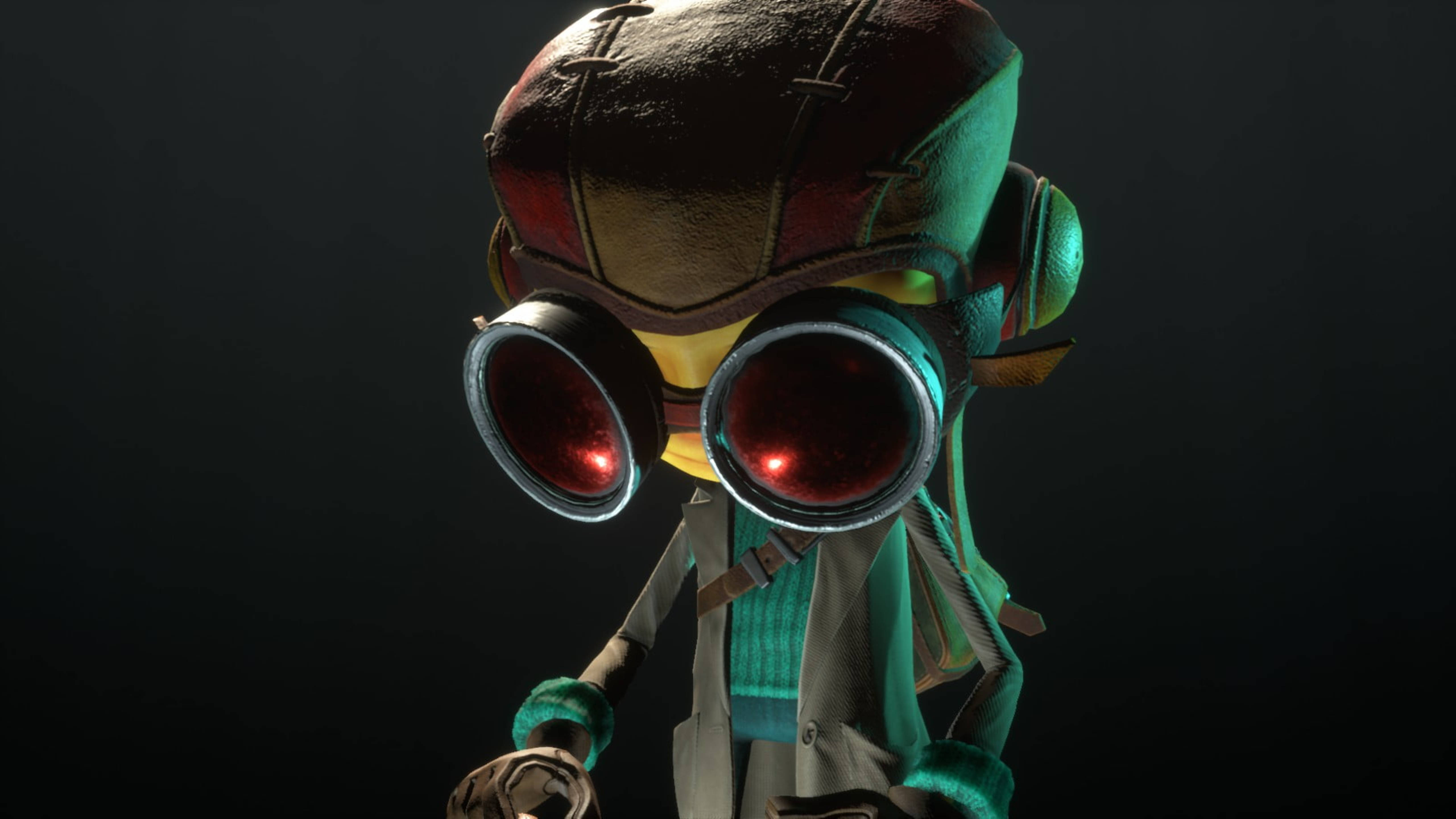 Psychonauts 桌布 壁紙 — 一個風格化的角色，戴著發光的紅色護目鏡和一個有補丁的頭盔，站在黑暗的背景前。