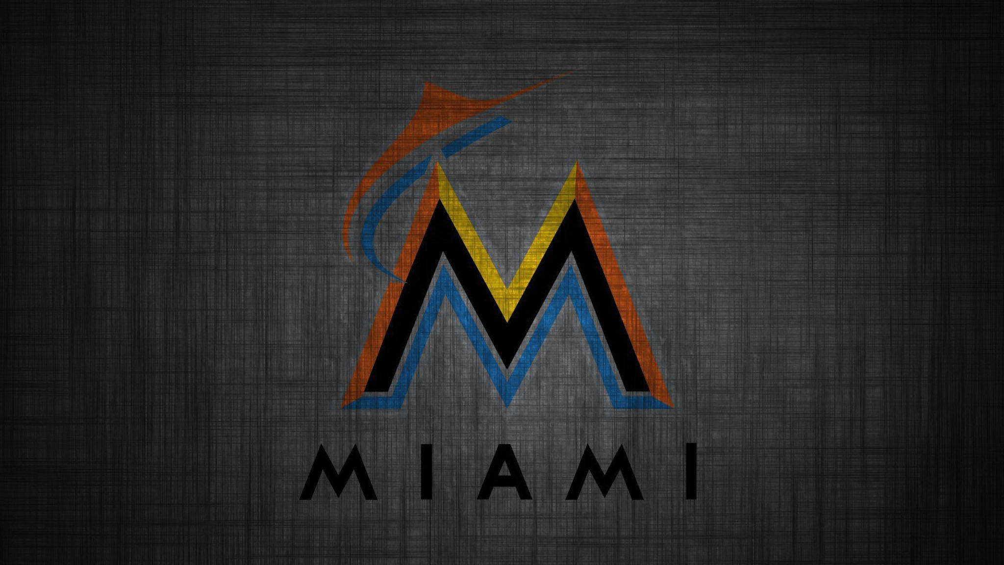 Marlins 桌布 壁紙 — 一個風格化的邁阿密標誌，帶有橙色、藍色和黃色點綴，在深色紋理灰色背景上脫穎而出。