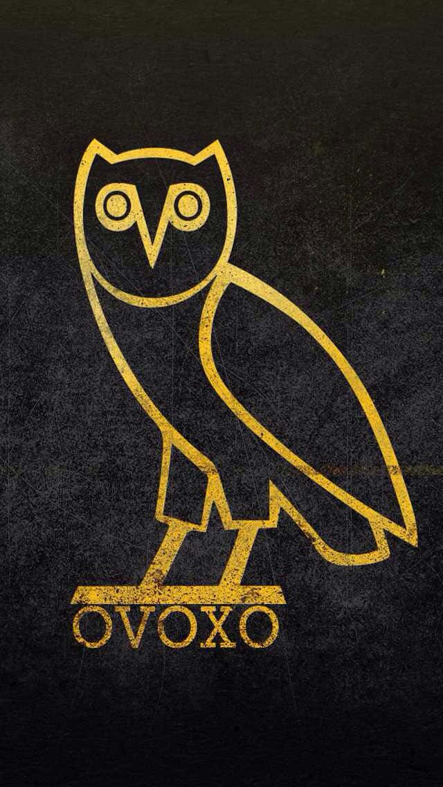 Drake Ovo Owl iPhone 桌布 壁紙 — 一個風格化的金色貓頭鷹標誌，帶有「OVOXO」文字，在紋理深色背景上脫穎而出。