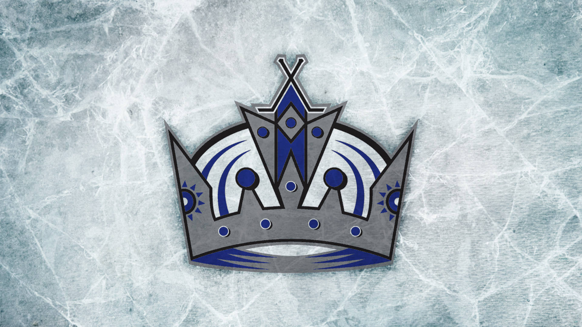 Los Angeles Kings 桌布 壁紙 — 一個風格化的銀藍色皇冠標誌放置在帶有可見刮痕的紋理冰場表面上。