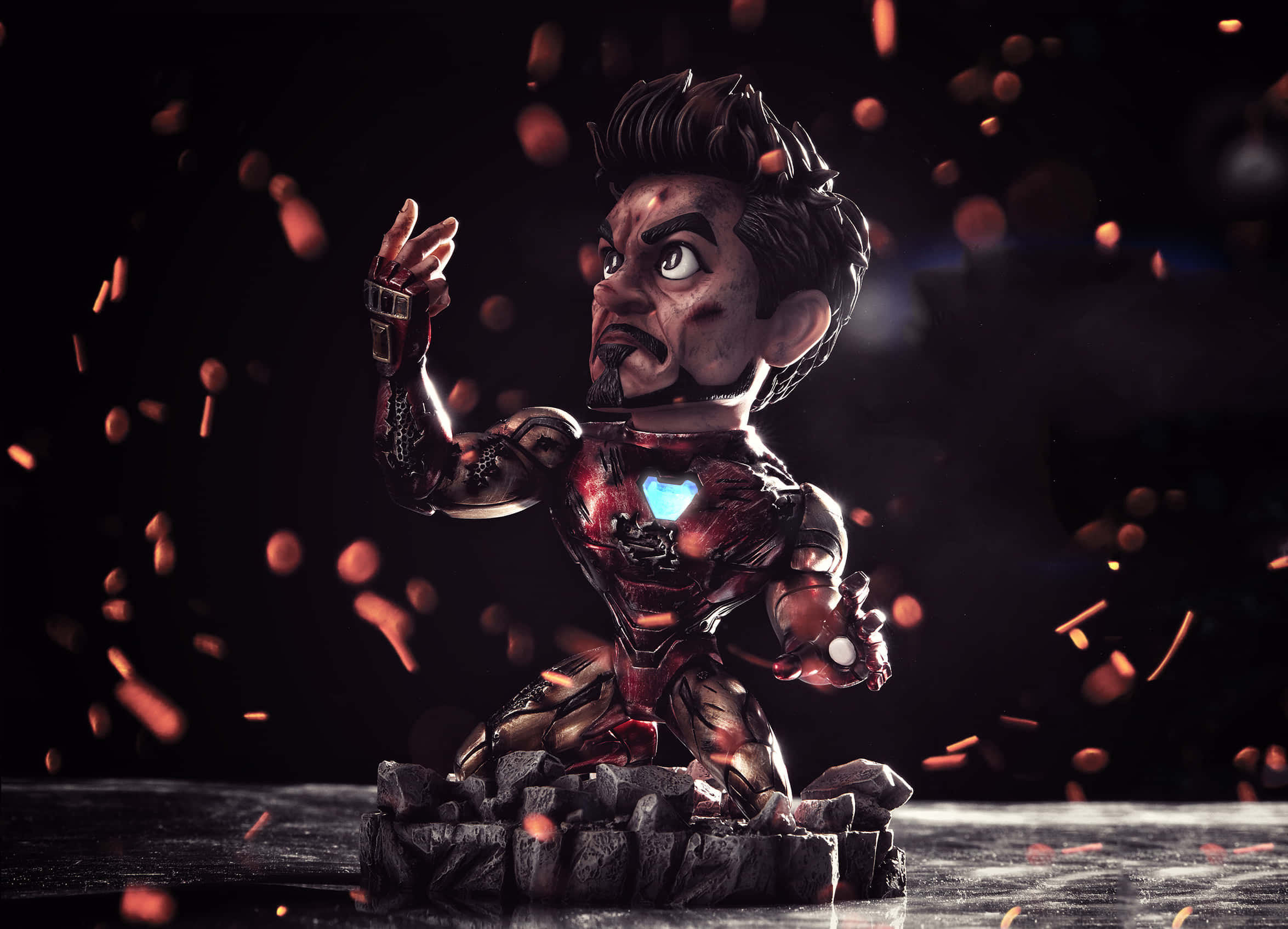 Iron Man Bobbleheads 桌布 壁紙 — 一個風格化的鋼鐵人人偶，帶有發光的弧形反應器和火花，背景為深色。