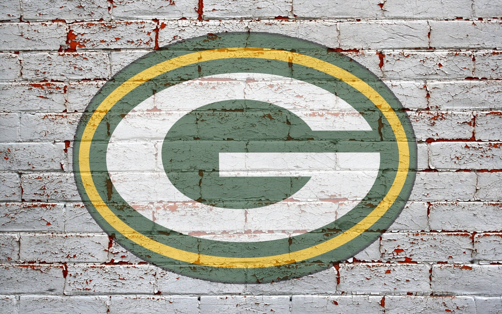 Packers 桌布 壁紙 — 一個飽經風霜的綠灣包裝工隊標誌，畫在裂開的白色磚牆上，油漆剝落，露出下面的紅磚。