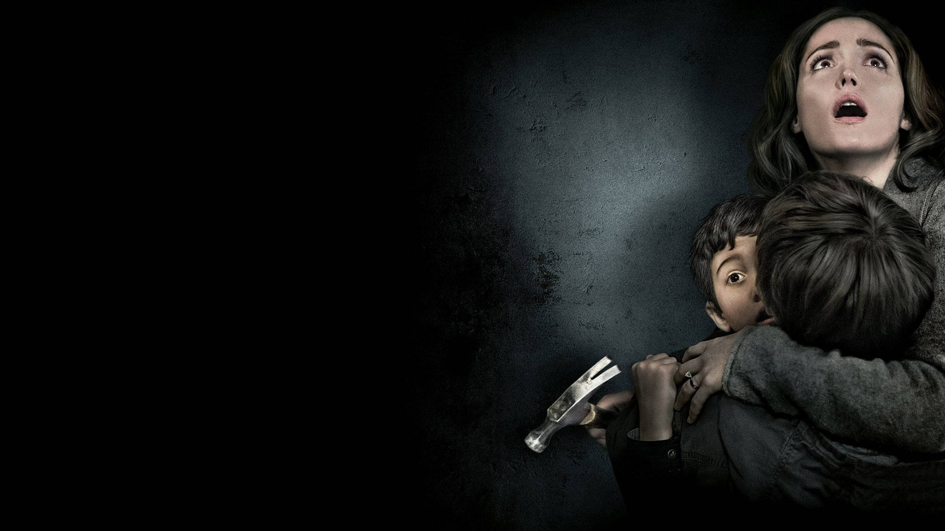 Insidious 桌布 壁紙 — 一個驚恐的女人緊緊抱住她的孩子，而一隻拿著錘子的手從他們背後的黑暗中出現。