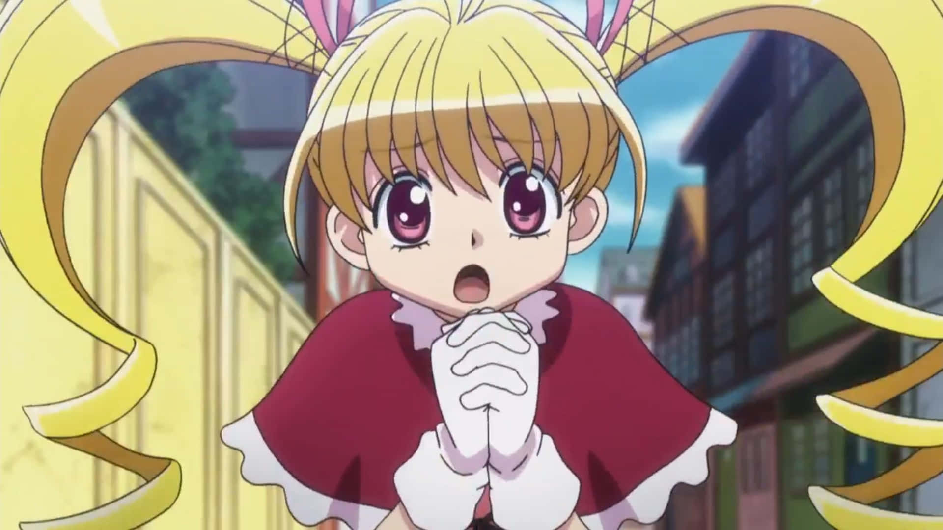 Hunter X Hunter Bisky 桌布 壁紙 — 一個驚訝的動漫女孩，金色雙馬尾和紫色眼睛，穿著紅色連衣裙，在模糊的城市背景下雙手合十。