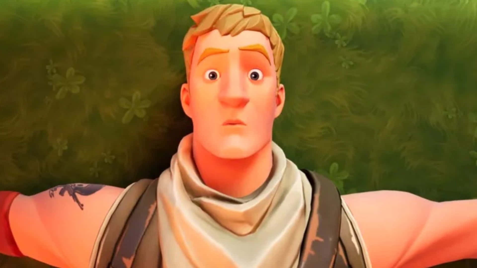 Jonesy Fortnite 桌布 壁紙 — 一個驚訝的動畫男性角色，金髮並有刺青，睜大眼睛躺在草地上。