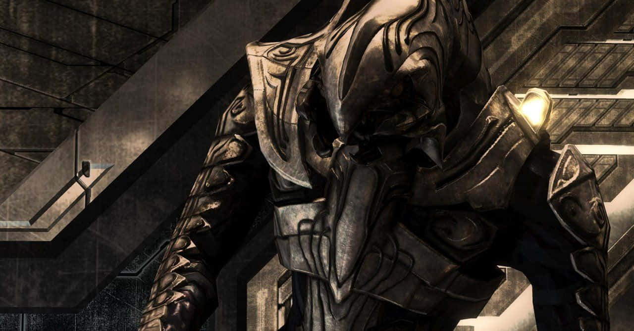 Halo Arbiter 桌布 壁紙 — 一個高大的裝甲戰士，帶有複雜的金屬板和發光的肩燈，站在昏暗的工業走廊中。