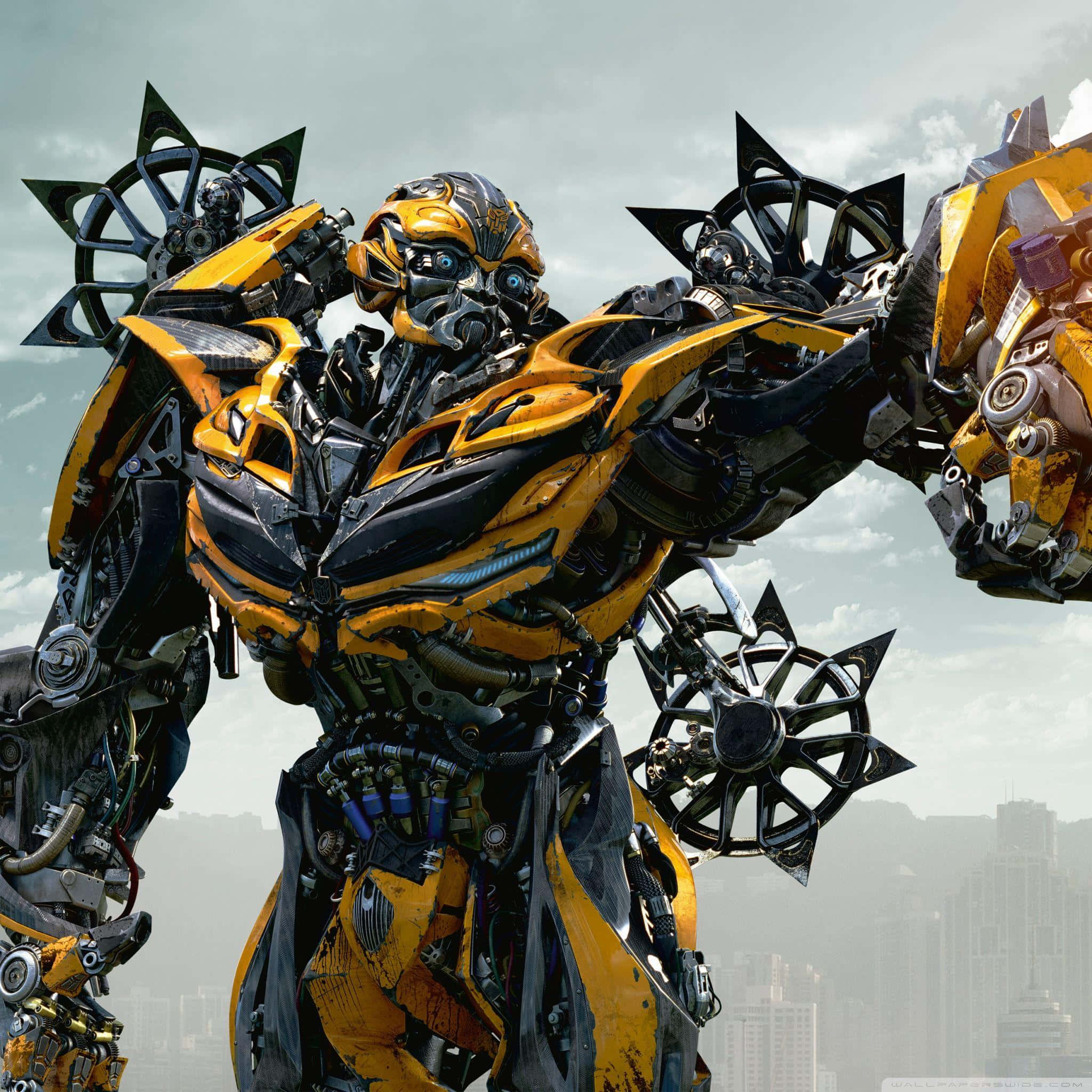 Transformers Bumblebee 桌布 壁紙 — 一個高大的黃黑機器人手持星形武器，英雄般地矗立在朦朧的城市天際線前。