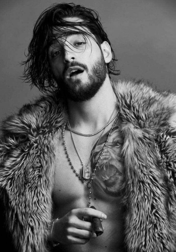 Maluma 桌布 壁紙 — 一個鬍鬚男濕髮穿著皮草大衣手持雪茄的黑白肖像。