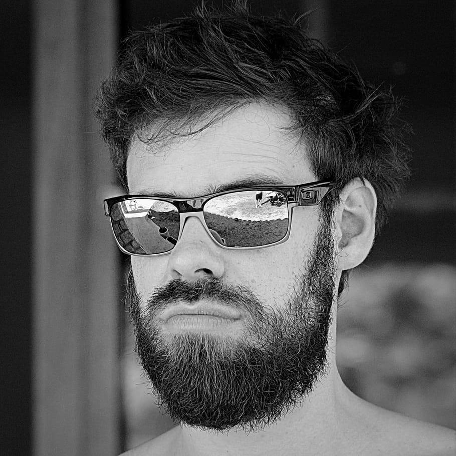 Sunglasses 桌布 壁紙 — 一個鬍鬚男的黑白肖像，戴著太陽眼鏡，鏡片反射出風景戶外景色。