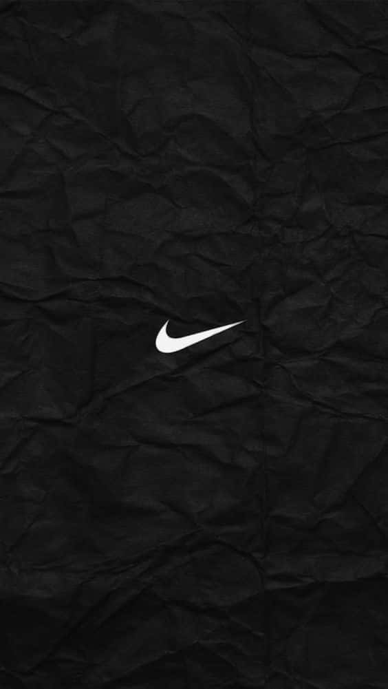 桌布 壁紙 — 一個鮮明的白色Nike swoosh標誌位於有紋理的黑色皺紙背景上。