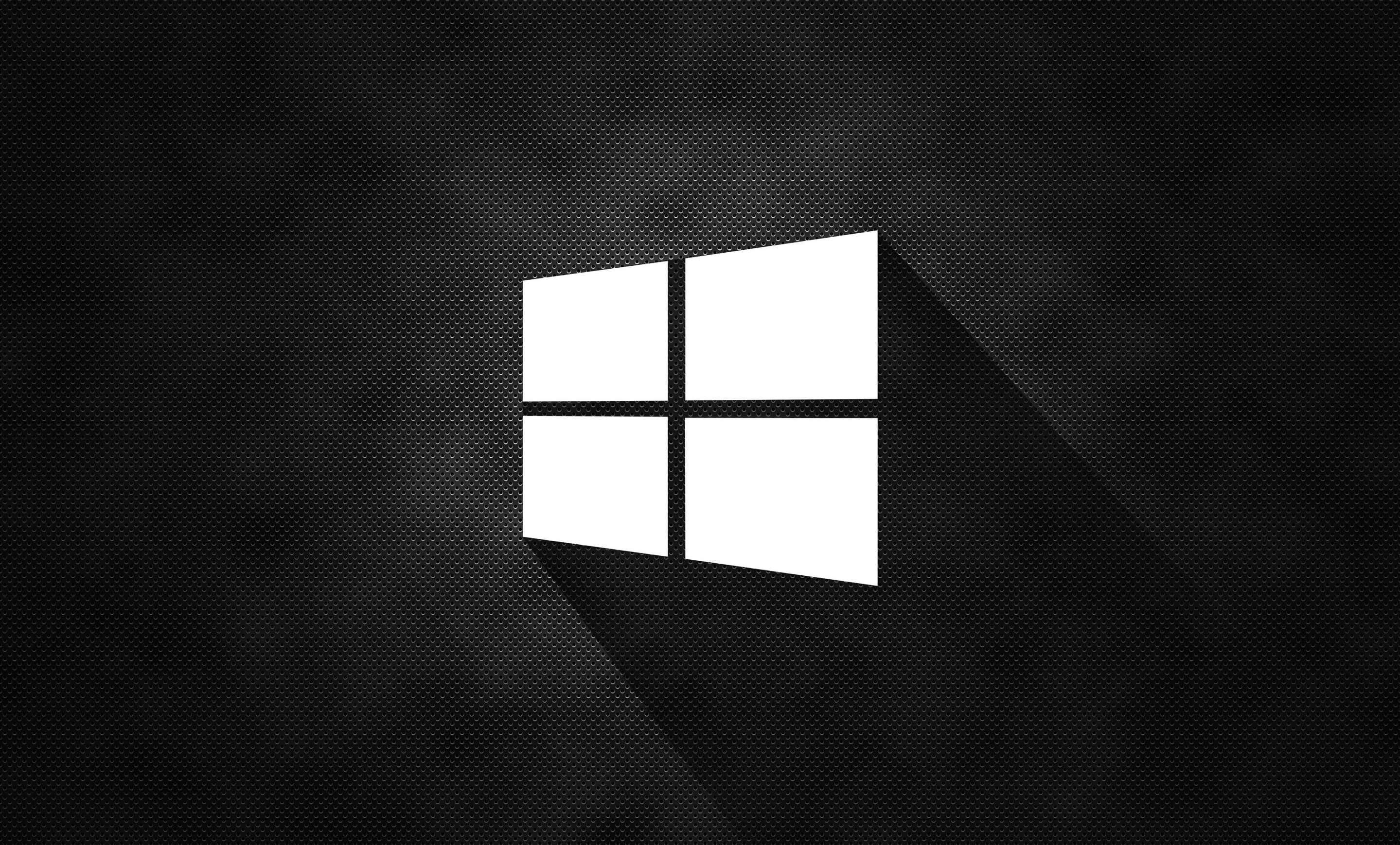 Windows 桌布 壁紙 — 一個鮮明的白色Windows標誌在帶有微妙漸變照明的紋理黑色背景上投下長長的陰影。