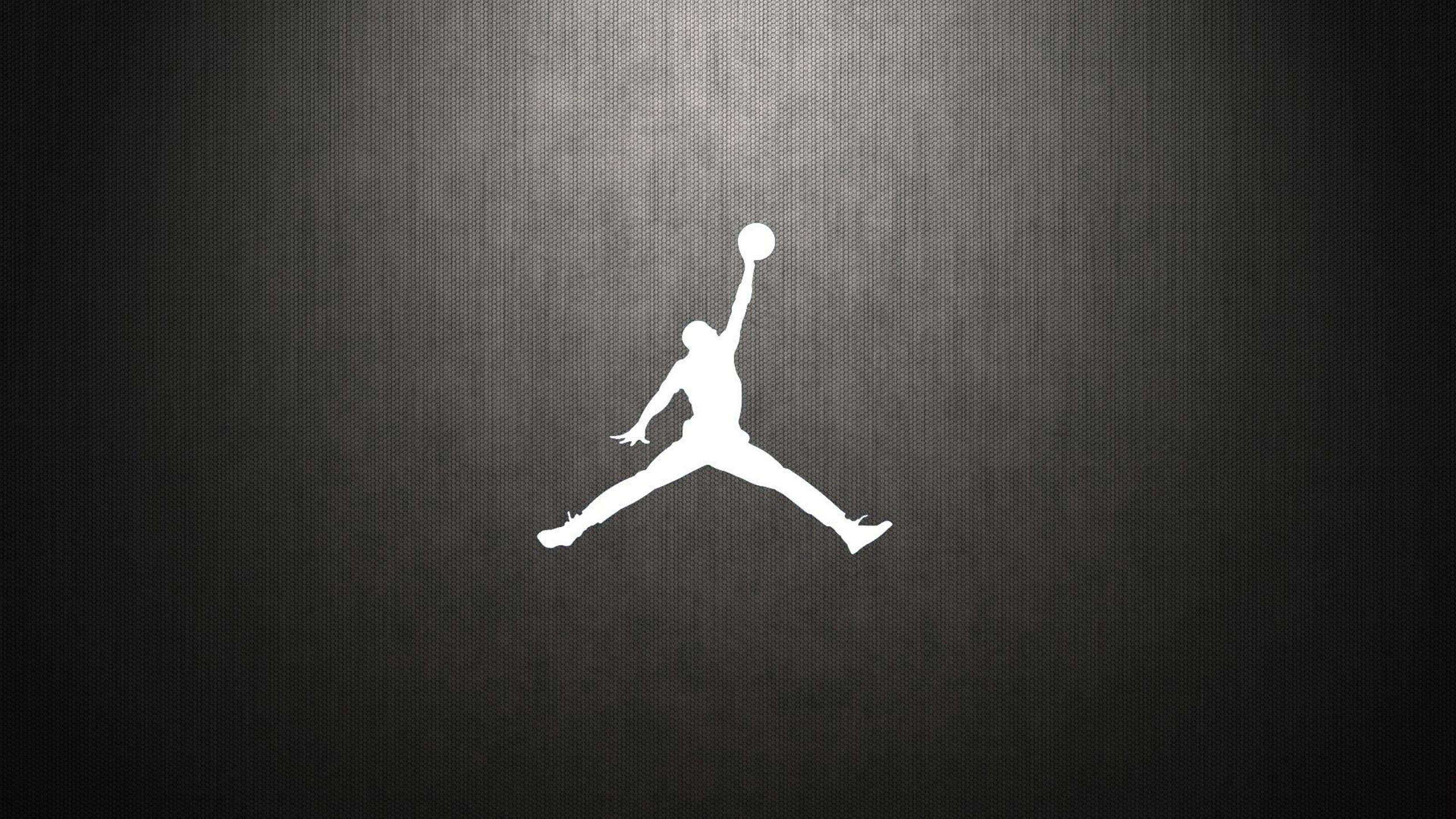 Air Jordan 桌布 壁紙 — 一個鮮明的白色剪影，標誌性的Jordan標誌在紋理深灰色漸變背景上躍起。