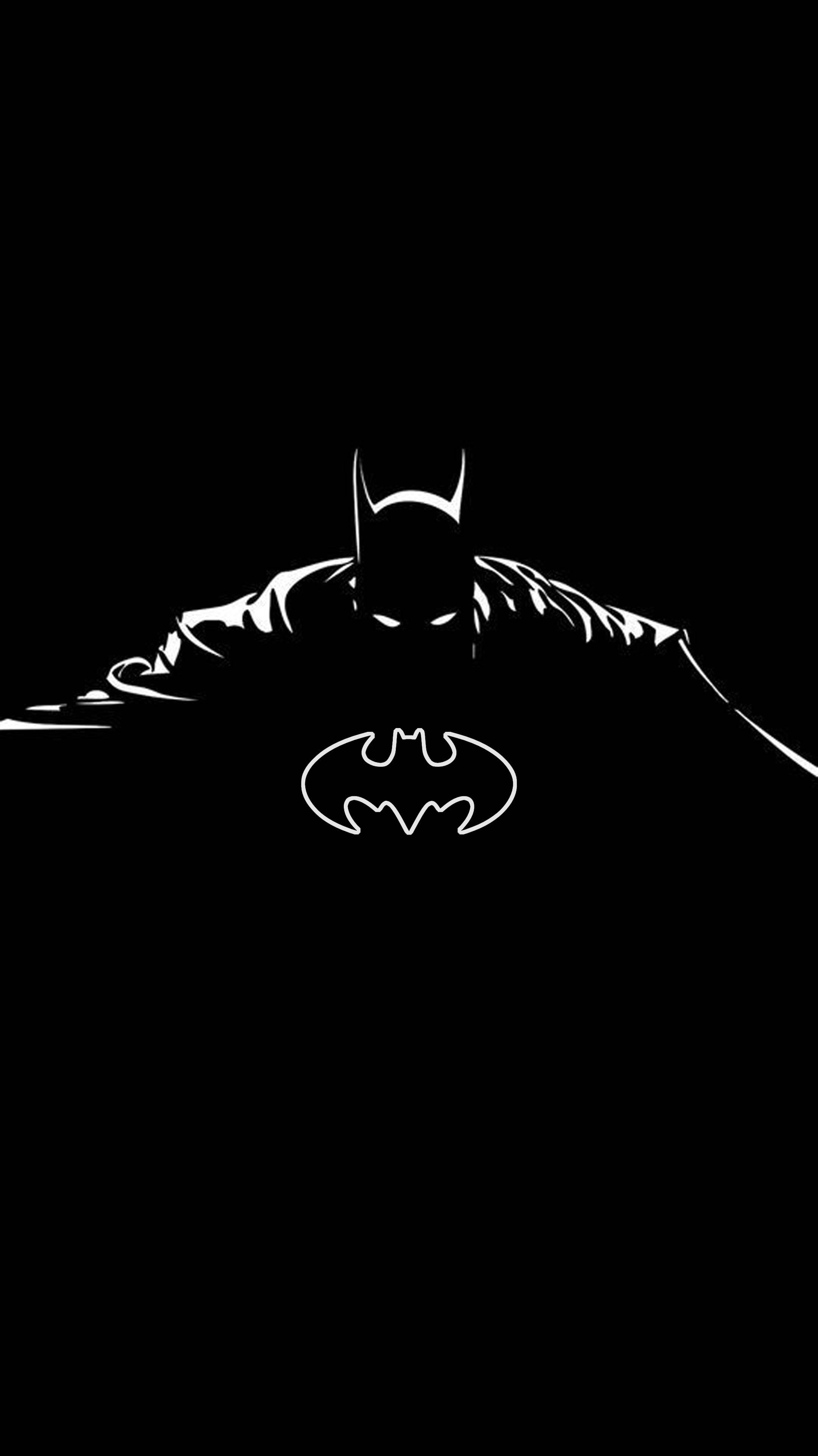 Batman Logo 桌布 壁紙 — 一個鮮明的白色蝙蝠俠剪影蹲在黑色背景上，他的標誌在下方發光。