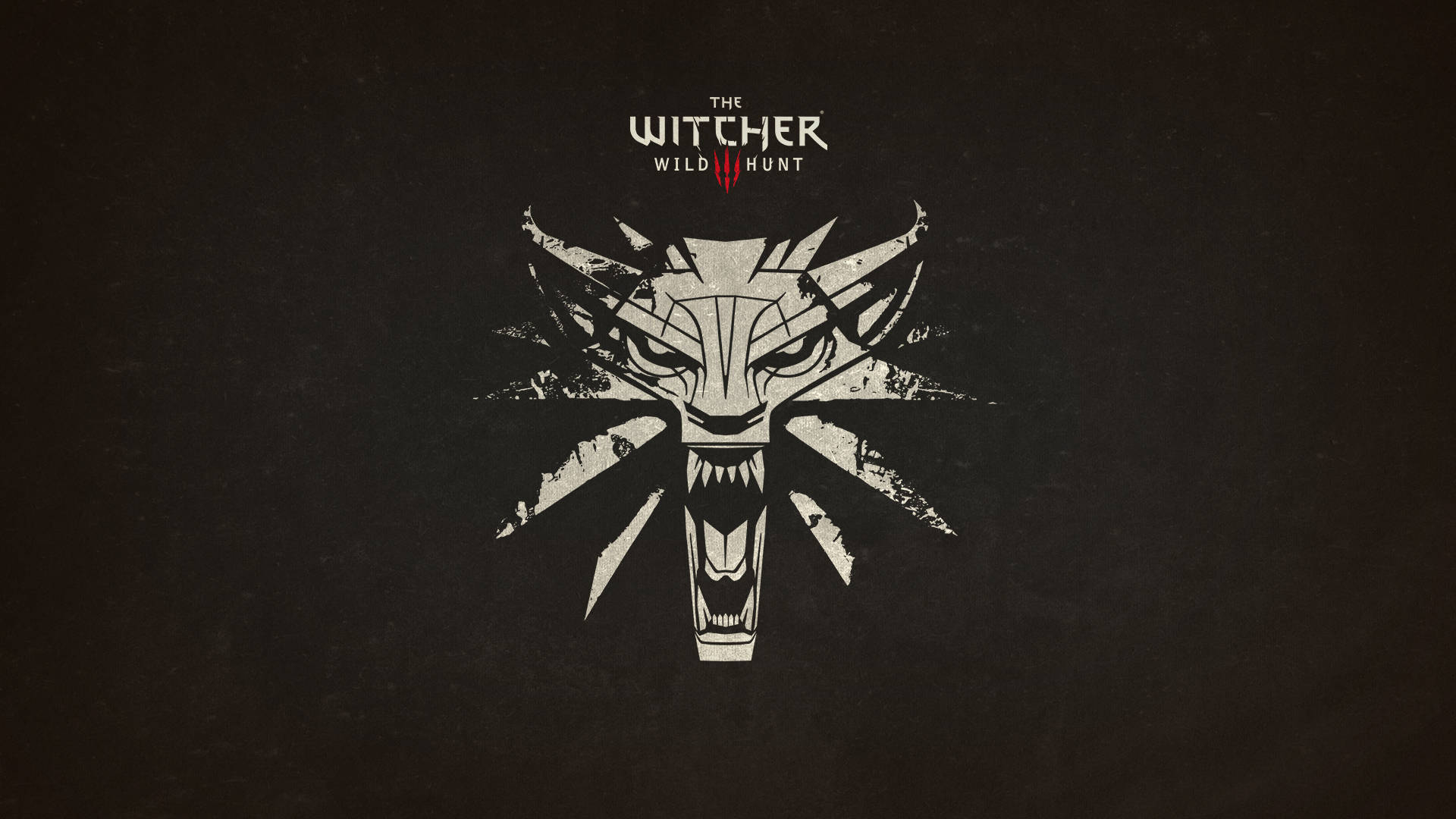 The Witcher 3 桌布 壁紙 — 一個鮮明的白色風格化狼頭標誌，帶有鋒利的牙齒和尖刺耳朵，居中在深色紋理背景上，上方有遊戲標題文字。