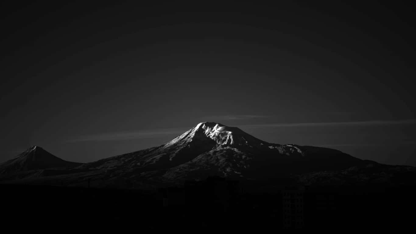 1366x768 AMOLED 桌布 壁紙 — 一個鮮明的黑白山峰剪影，山頂積雪在漸變天空下閃耀。