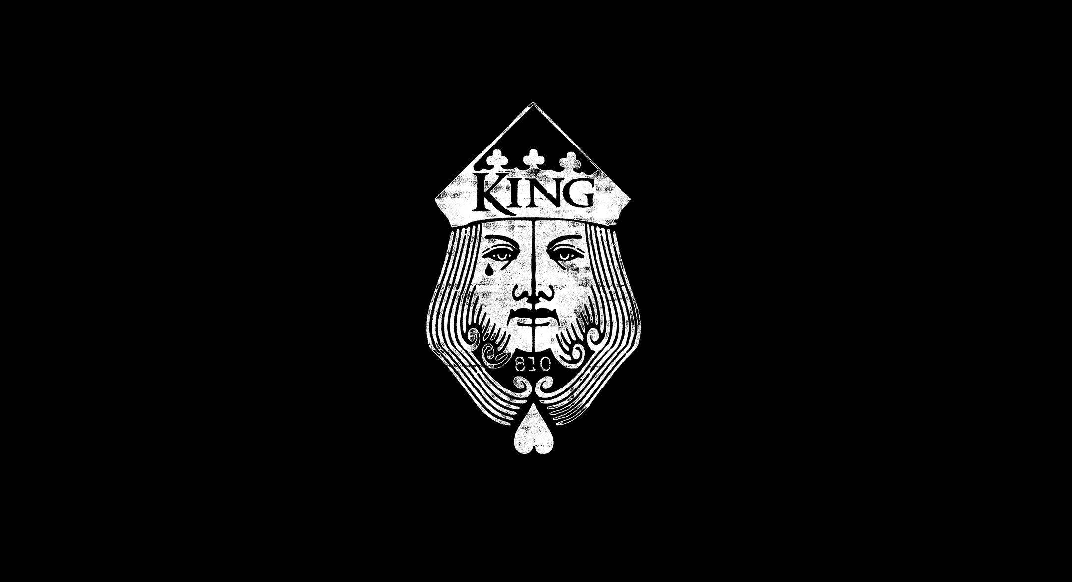 Black King 桌布 壁紙 — 一個鮮明的黑白插圖，描繪國王撲克牌面孔，帶有華麗的鬍鬚和王冠，背景為純黑色。