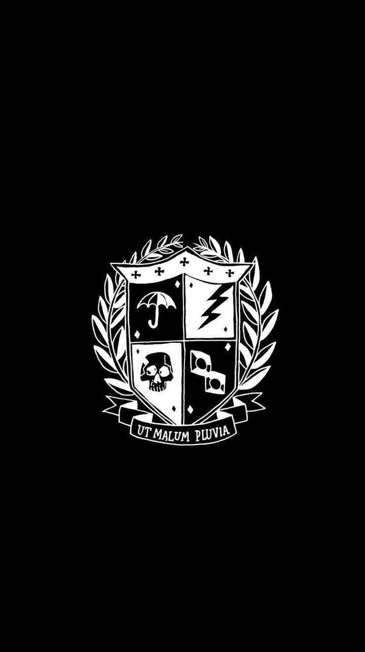 Academy 桌布 壁紙 — 一個鮮明的黑白紋章，四個象限分別有雨傘、閃電、骷髏頭和左輪手槍，周圍環繞月桂花環。