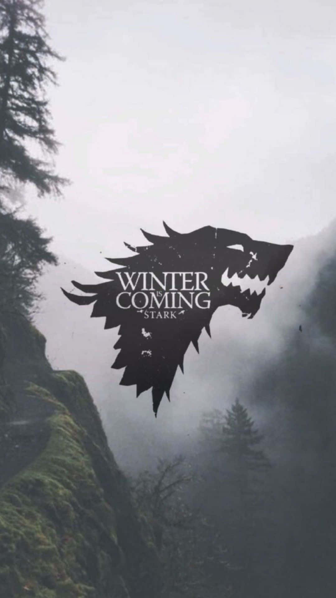 手機 桌布 壁紙 — 一個鮮明的黑色冰原狼徽章，上面寫著「Winter is Coming」，以單色調漂浮在霧氣瀰漫的山林之上。