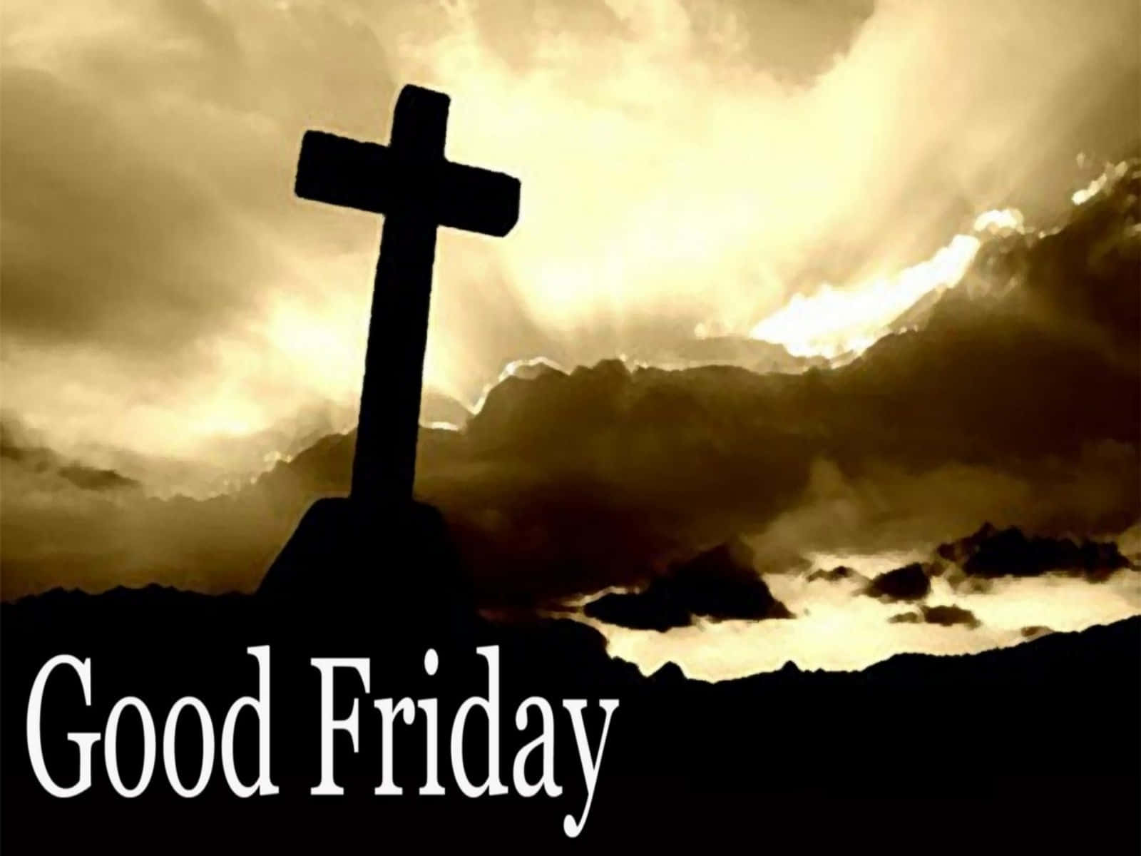 Good Friday 桌布 壁紙 — 一個鮮明的黑色十字架剪影矗立在山丘上，背景是戲劇性的金色日落天空和翻滾的雲彩。