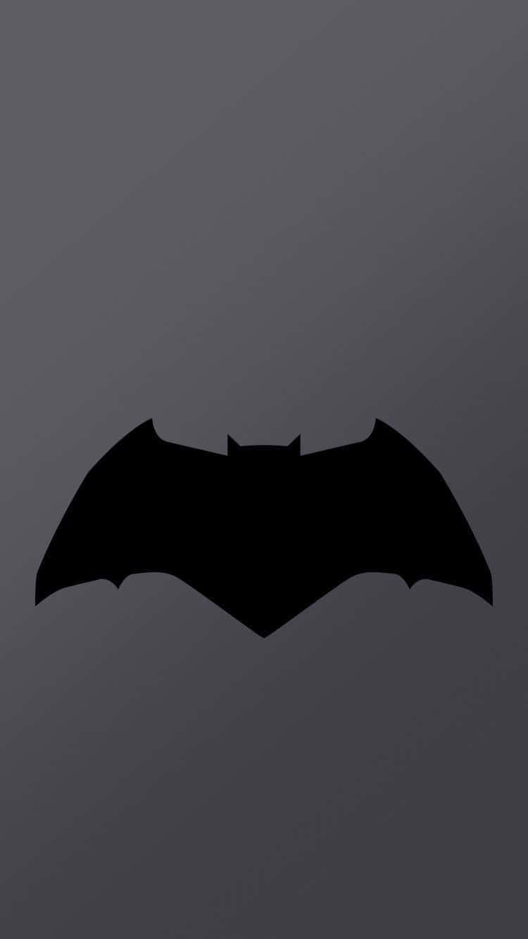 Batman Logo 桌布 壁紙 — 一個鮮明的黑色蝙蝠符號，居中放置在帶有微妙斜向照明的漸變灰色背景上。